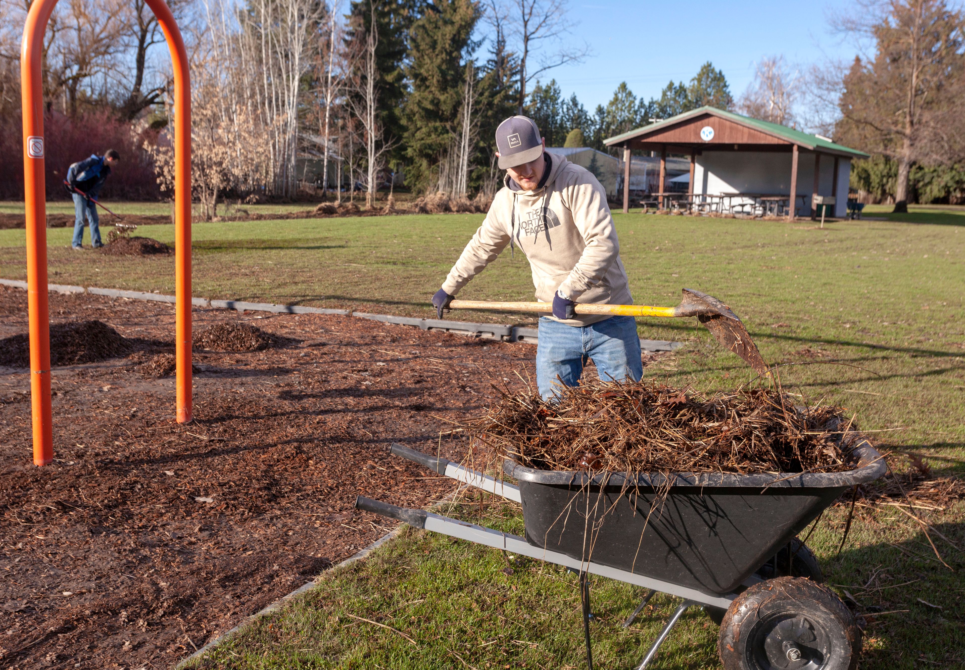 Bodie McNamara, right, and Gabriel Raber from the Moscow Parks Department clean up debris from floodwater at Kiwanis Park on Wednesday in Moscow.