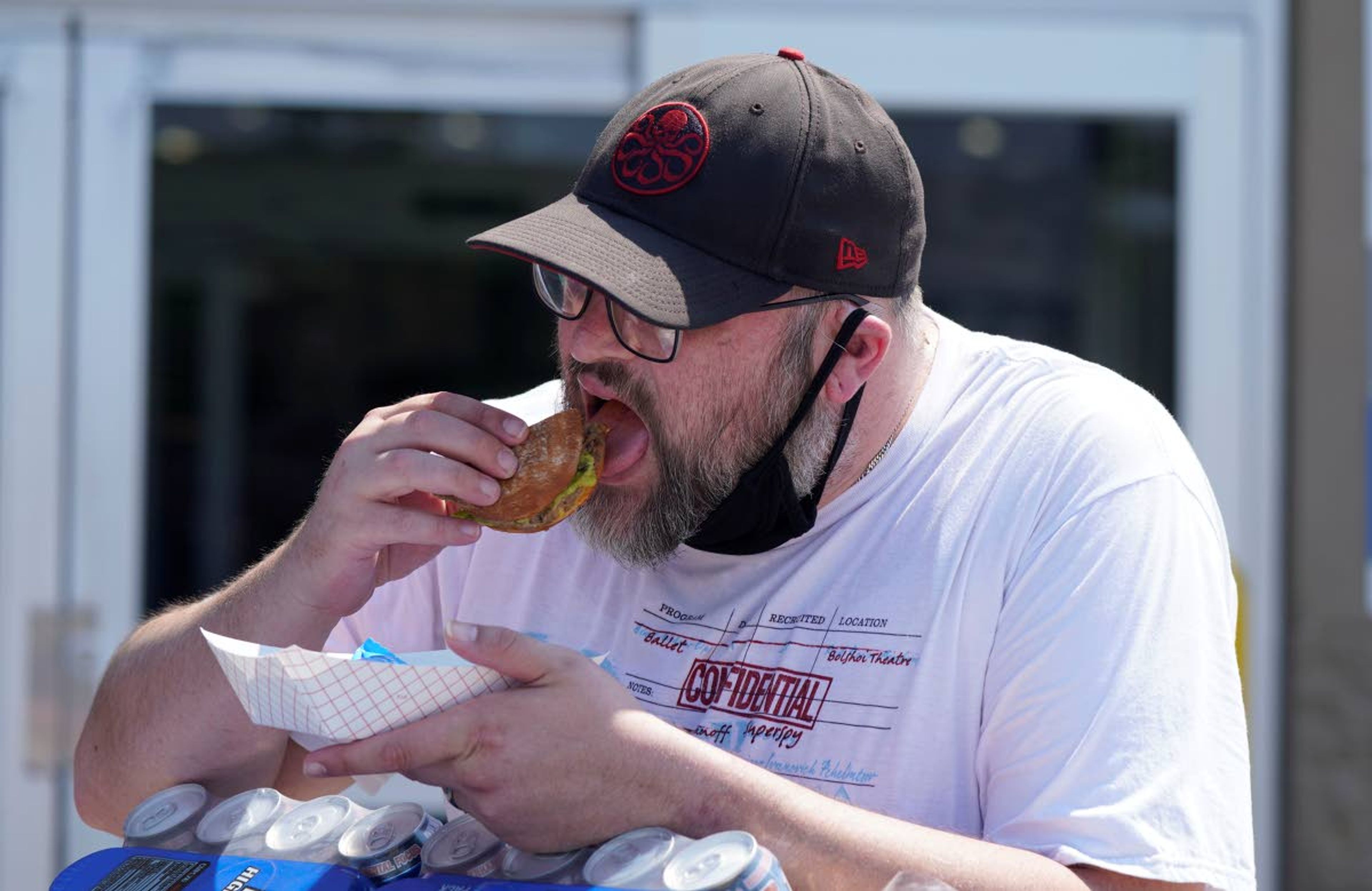 A man that identified himself as Zeiis east a free food sample outside a Sam's Club Friday, June 18, 2021, in McKinney, Texas. When the pandemic was declared in March 2020, retailers worried about the potential spread of the coronavirus so they cut off free sampling of everything from food to makeup to toys. But now with vaccinations rolling out and the threat of COVID-19 easing in the U.S., food vendors and stores are feeling confident enough to revive the longstanding tradition.(AP Photo/LM Otero)