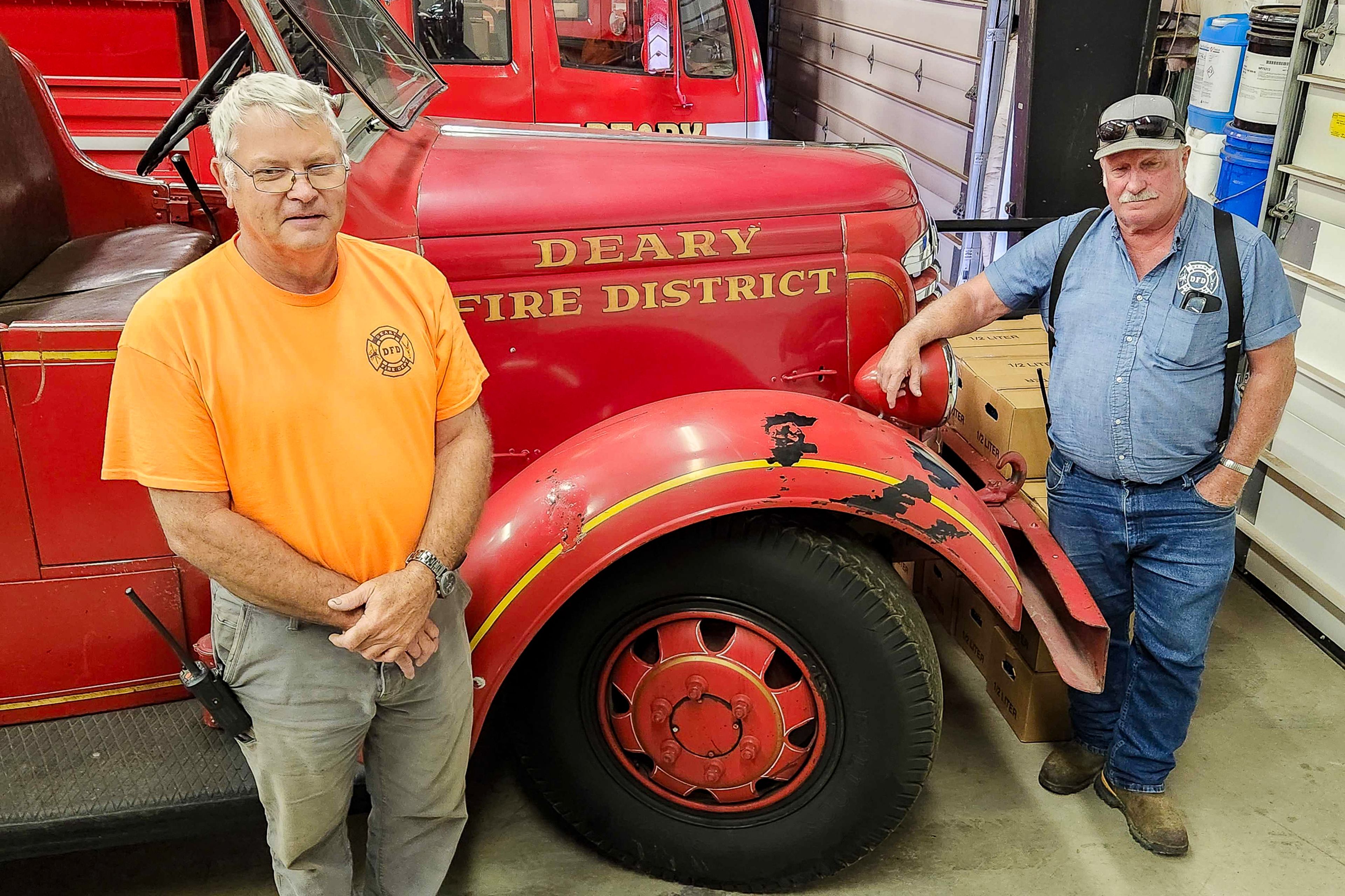 Tim Jones, left, and Denny Proctor stand next to a 1936 antique fire engine inside the Deary Fire Department on Thursday. Jones and Proctor have volunteered at the department for 50 years.