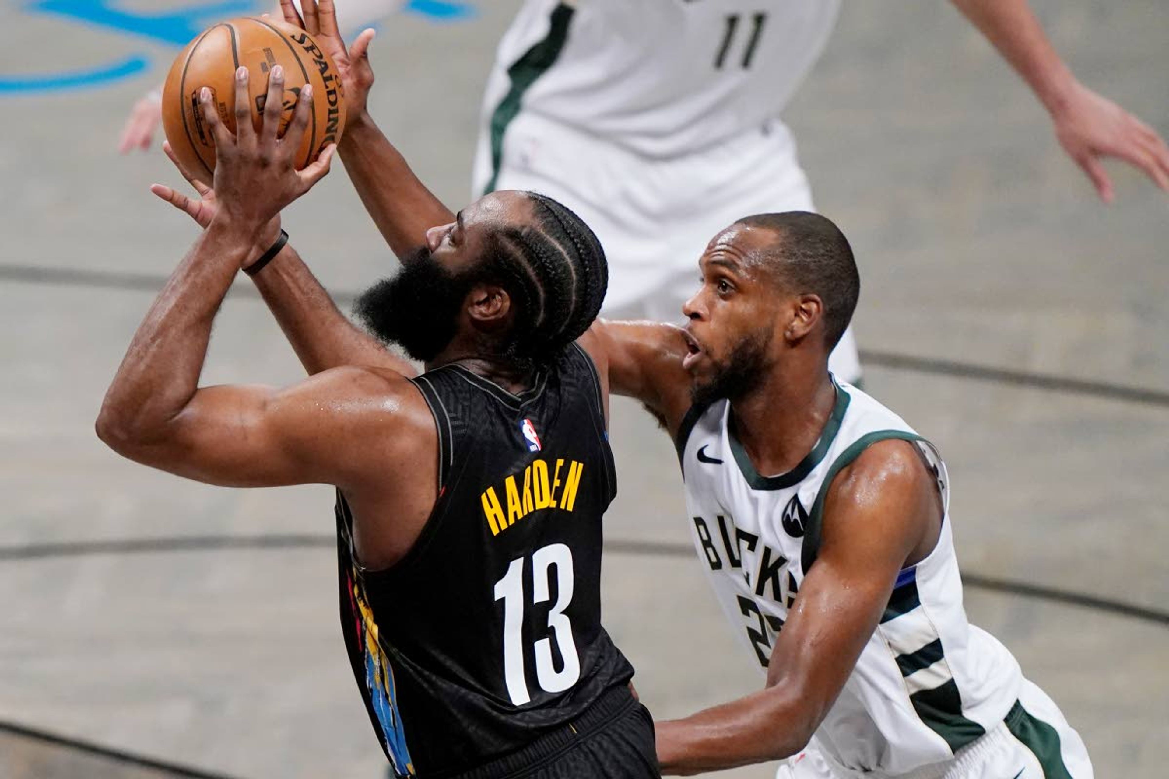 Milwaukee Bucks forward Khris Middleton (22) defends against Brooklyn Nets guard James Harden (13) during the second half of Game 5 of a second-round NBA basketball playoff series Tuesday, June 15, 2021, in New York. (AP Photo/Kathy Willens)