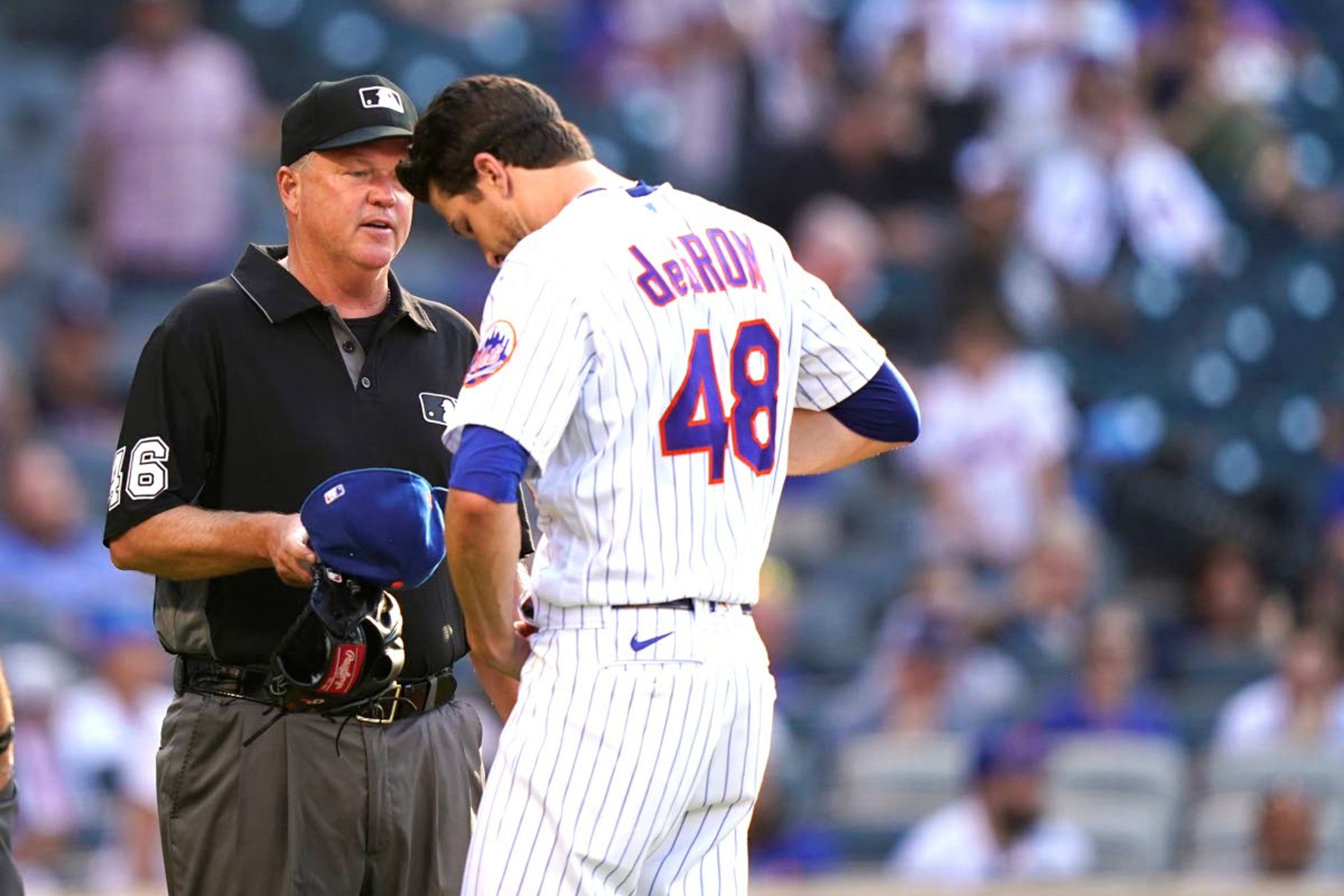 Associated PressMets starter Jacob deGrom (48) unbuckles his belt for third base umpire Ron Kulpa (46) after leaving the mound after pitching the top of the fifth inning of a baseball game against the Braves on Monday in New York.