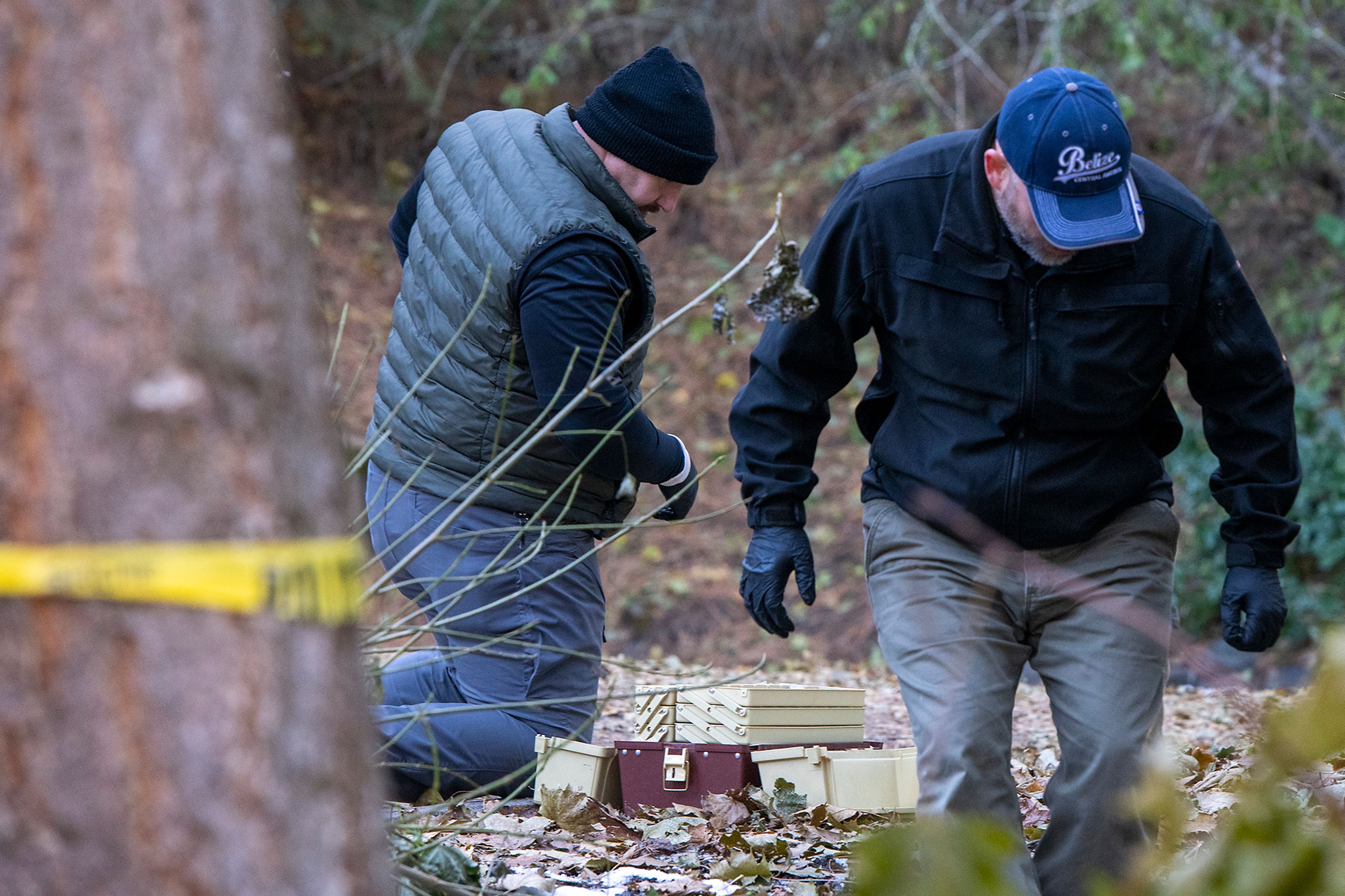 Officers investigate Monday in a parking lot behind the home where four University of Idaho students were stabbed in a quadruple homicide on King Road in Moscow.