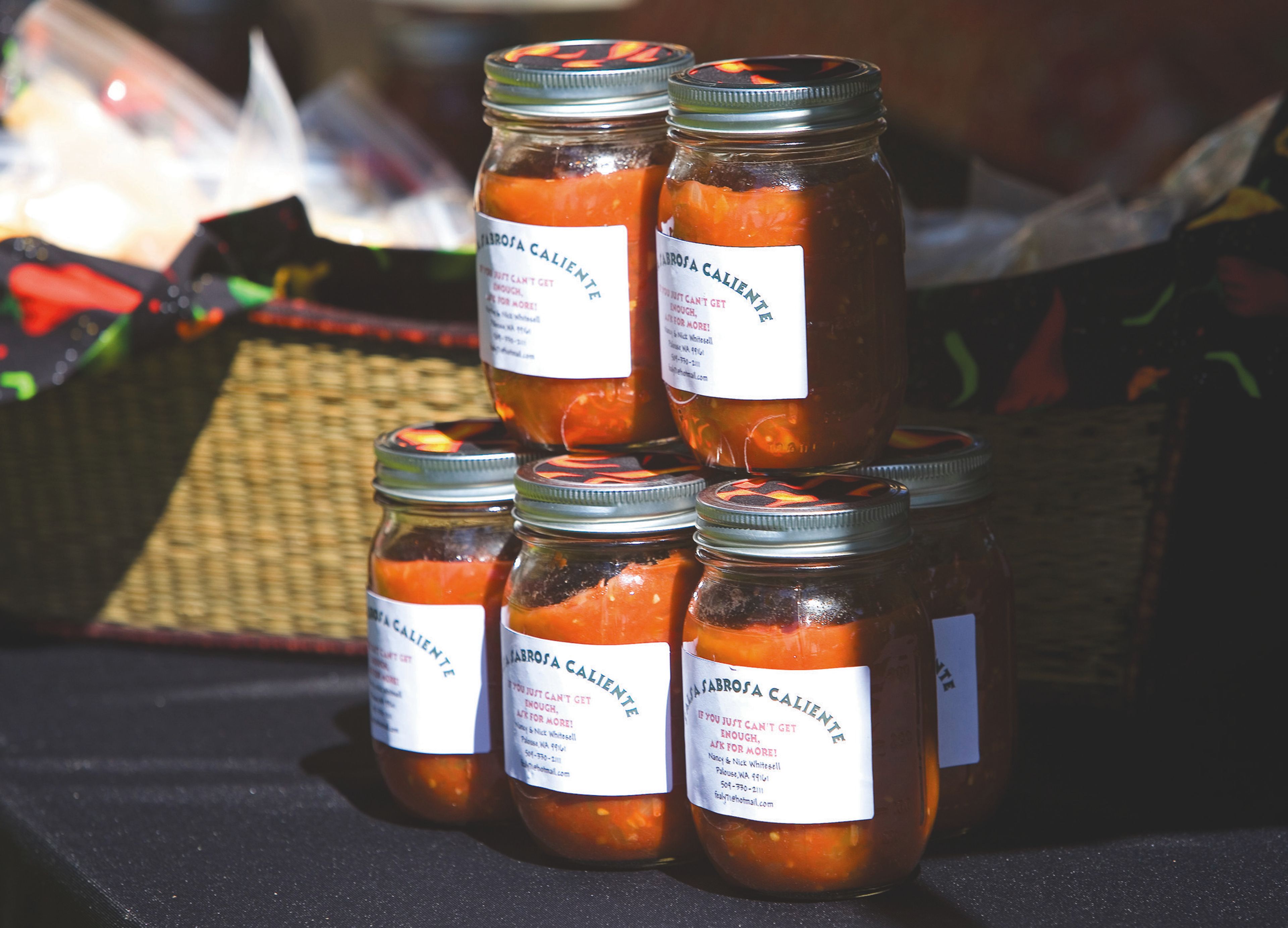 Salsa jars for sale by Nick and Nancy Whitesell are stacked on their table at the Palouse Music Festival and pig roast on July 28, 2012, at Hayton-Greene Park in Palouse.