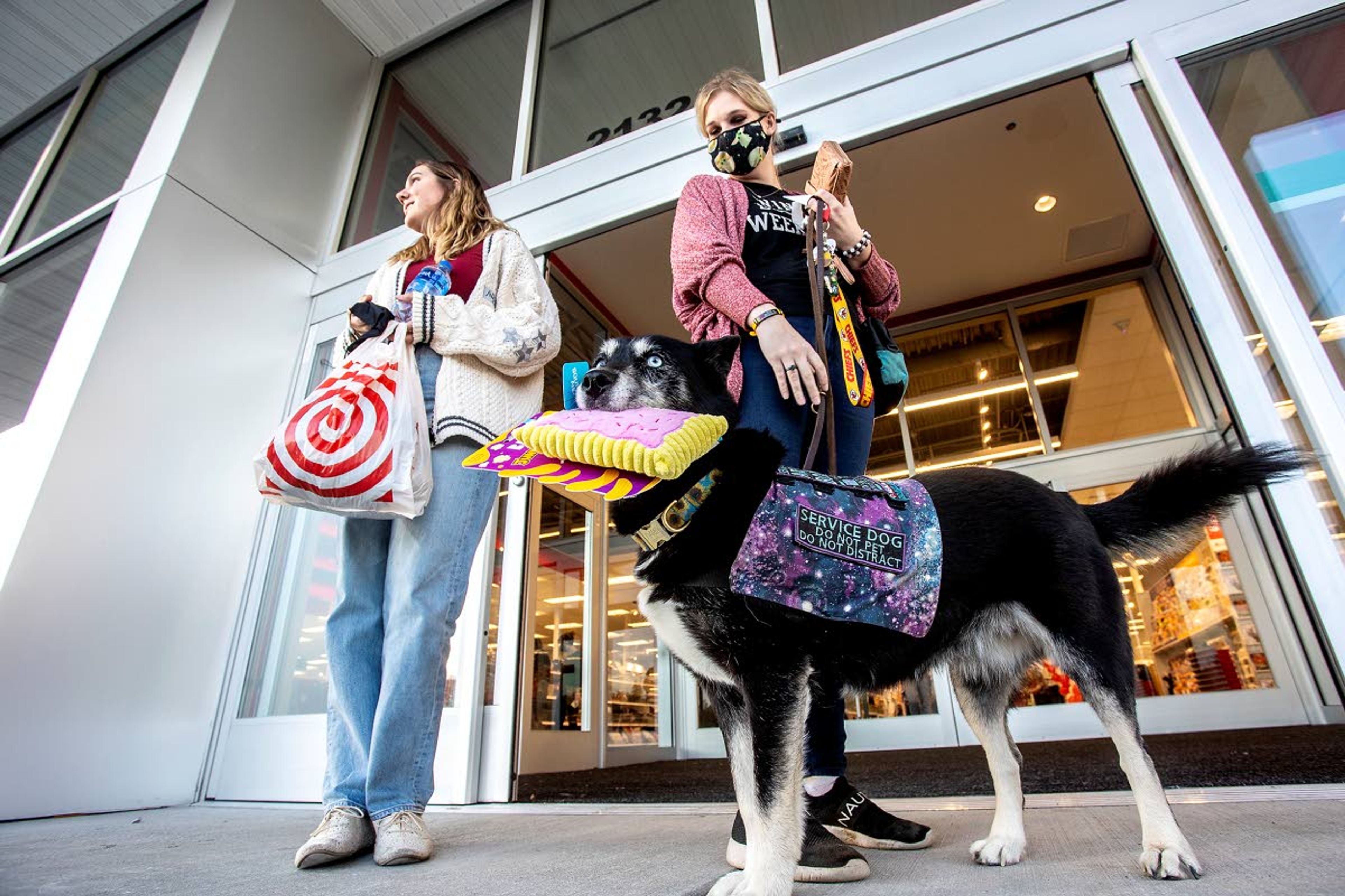 Darby holds a Bark Box shaped like a Pop Tart that he picked out for himself at the new Target as his owner Shannon McLachlan holds his leash and Dani Hodgson stands by after shopping at the new Target in Moscow on Tuesday.