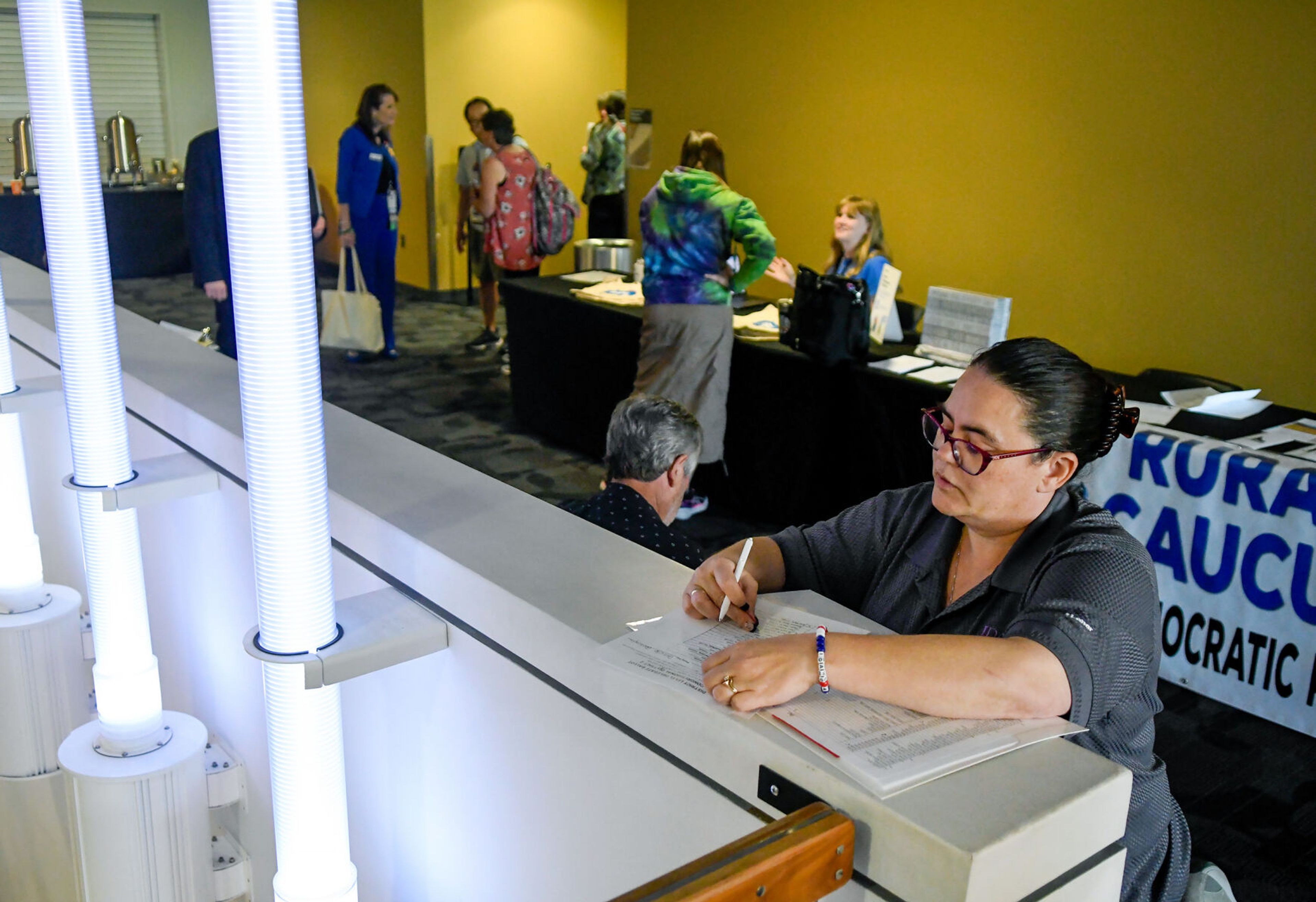 Tracie Roberts, of Pocatello, fills out a District Level Delegate Ballot along the edge of the staircase at the Pitman Center during the Idaho Democratic Convention on Saturday in Moscow.