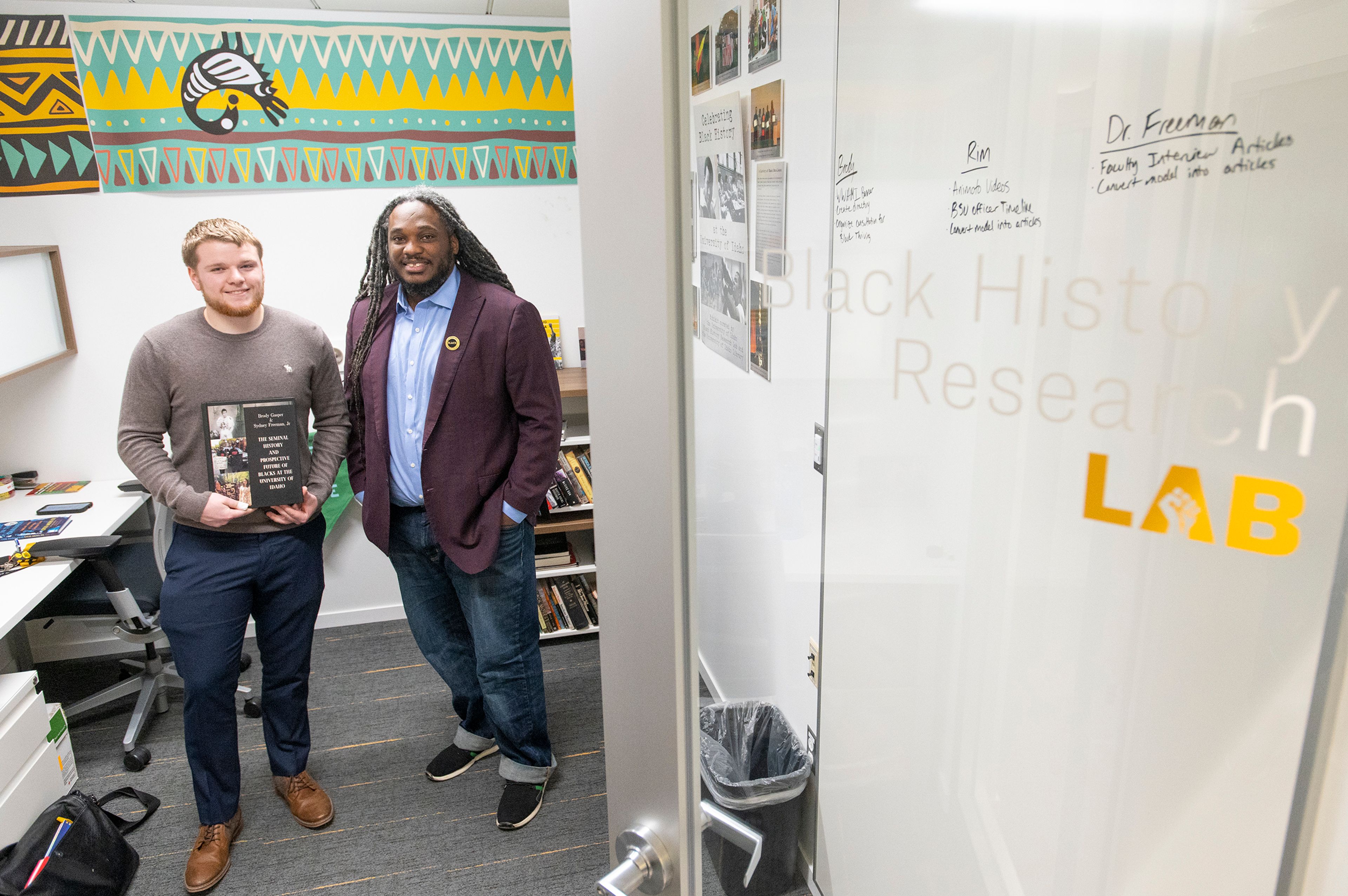 Project Manager Brody Gasper and director Sydney Freeman, Jr., pose Monday with a copy of their new book, “The Seminal History and Prospective Future of Blacks at the University of Idaho,” in the Black History Research Lab on campus in Moscow.