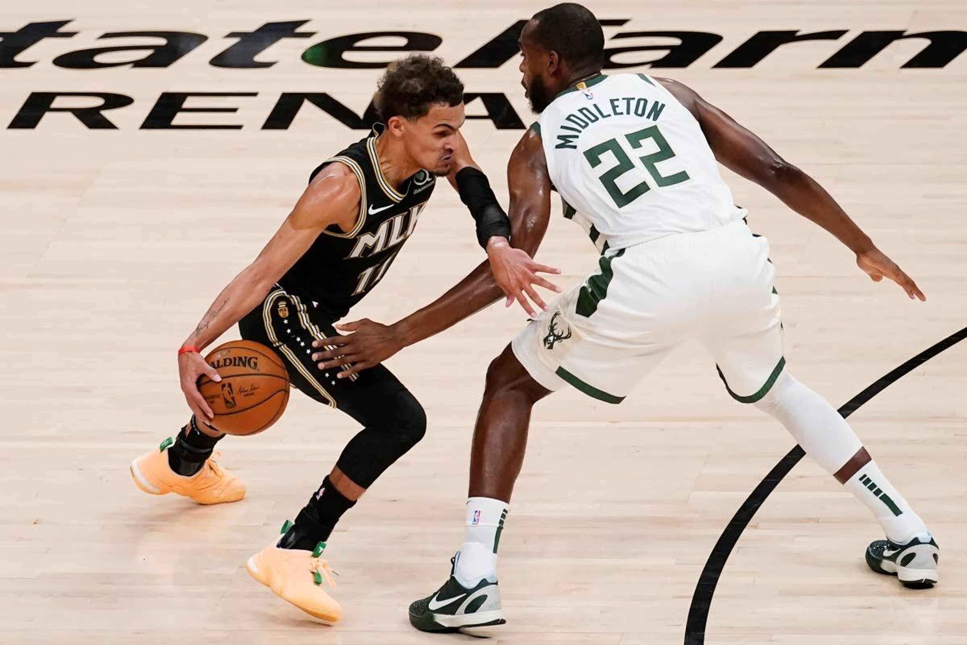 Atlanta Hawks guard Trae Young (11) drives past Milwaukee Bucks forward Khris Middleton (22) during the first half of Game 6 in the NBA basketball playoffs Eastern Conference finals Saturday, July 3, 2021, in Atlanta. (AP Photo/John Bazemore)