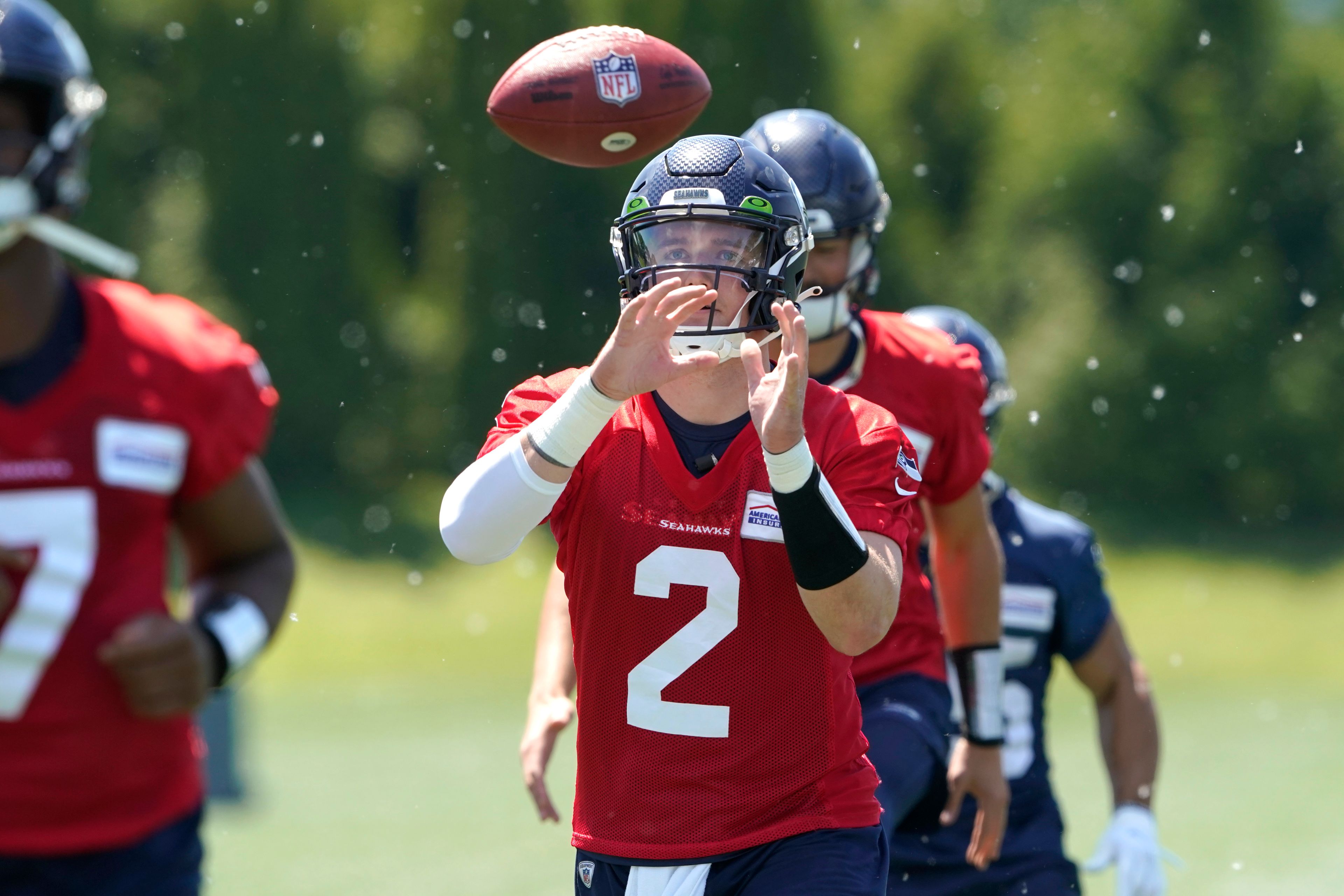 Seattle Seahawks quarterback Drew Lock reaches for the football during a drill at NFL football practice, Tuesday, May 31, 2022, in Renton, Wash. (AP Photo/Ted S. Warren)