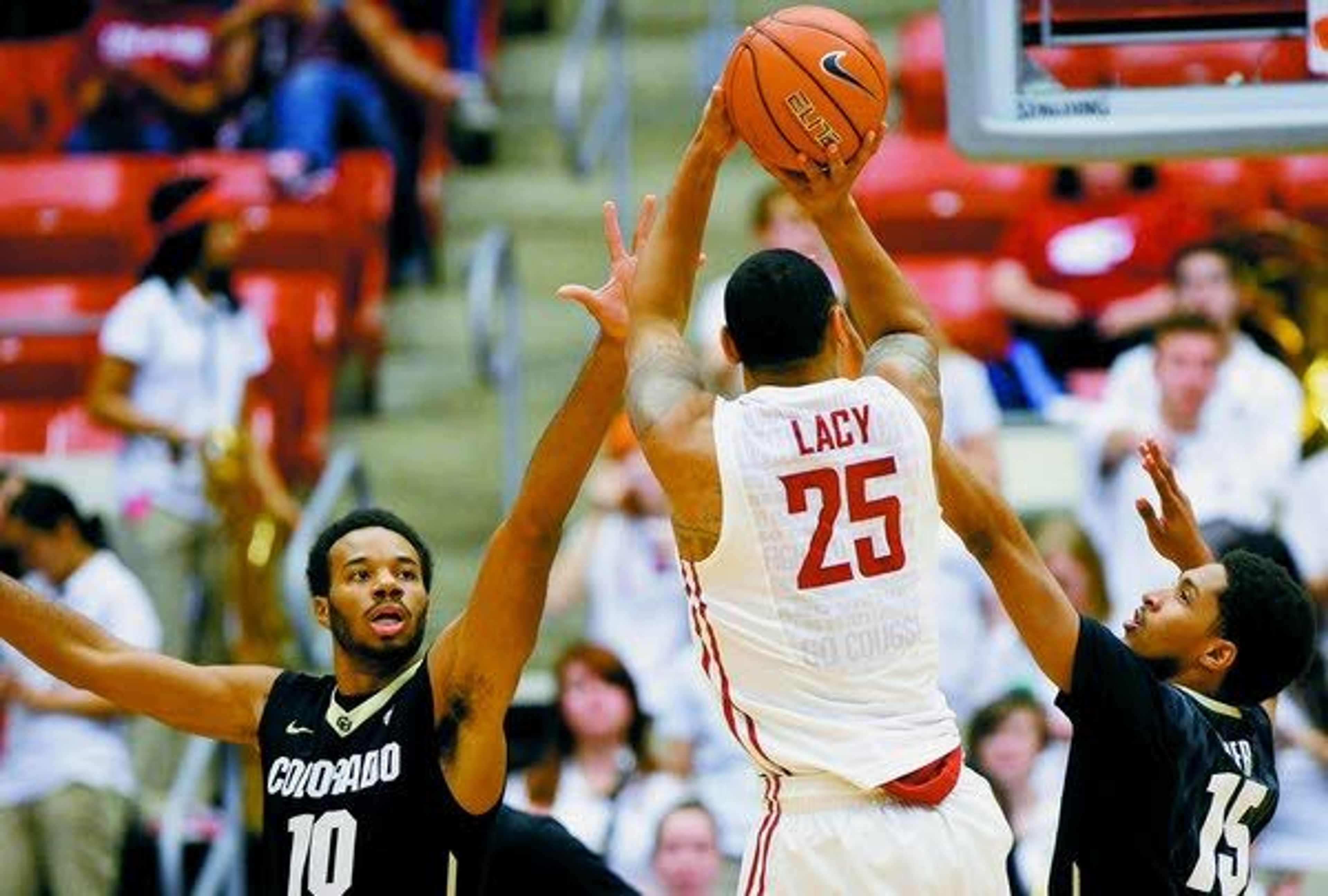 Washington State guard DaVonte' Lacy (25) shoots over Colorado guards Tre'Shaun Fletcher (10) and Dominique Collier (15) during the first half Saturday in Pullman