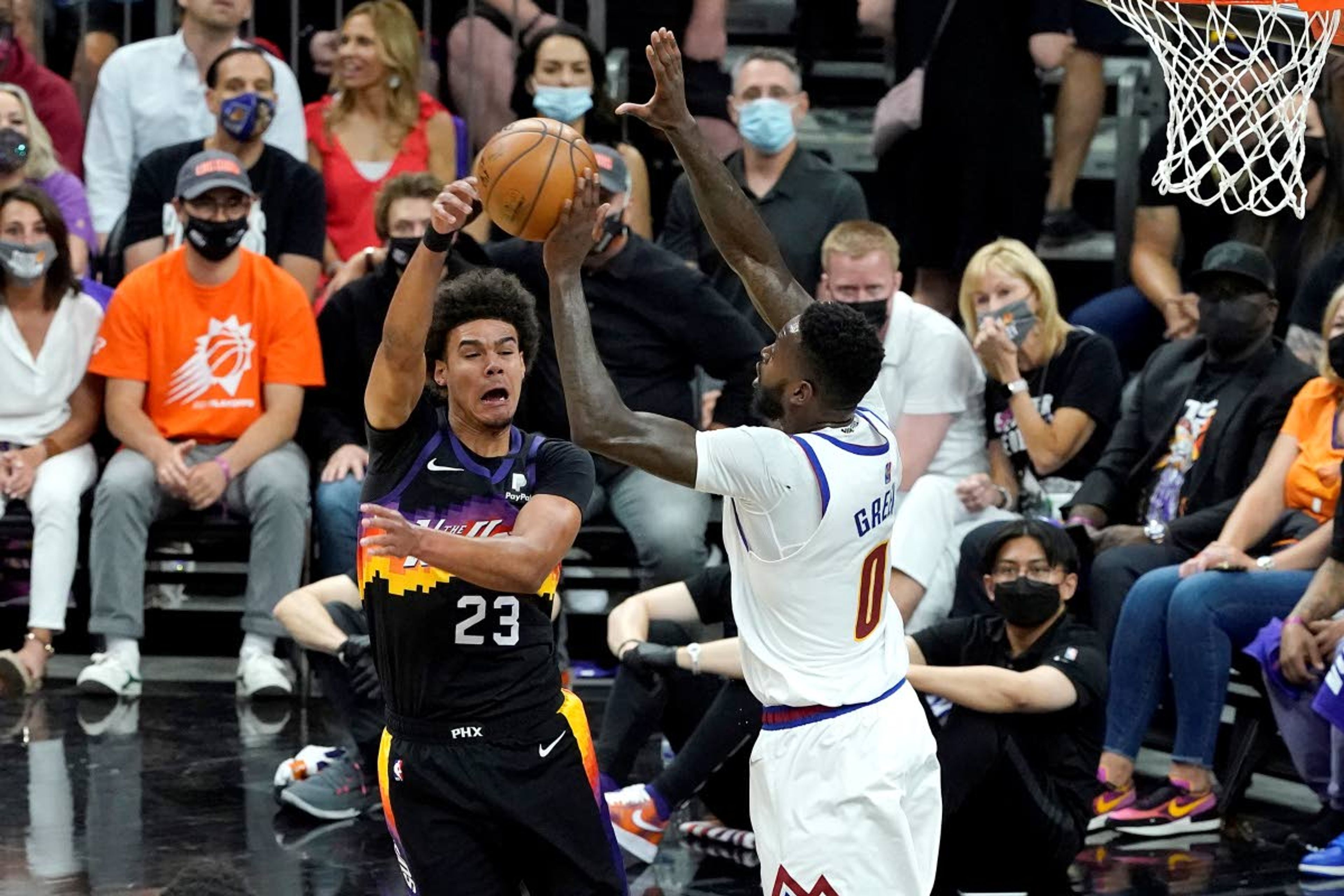 Phoenix Suns forward Cameron Johnson (23) passes around Denver Nuggets forward JaMychal Green (0) during the first half of Game 2 of an NBA basketball second-round playoff series, Wednesday, June 9, 2021, in Phoenix. (AP Photo/Matt York)