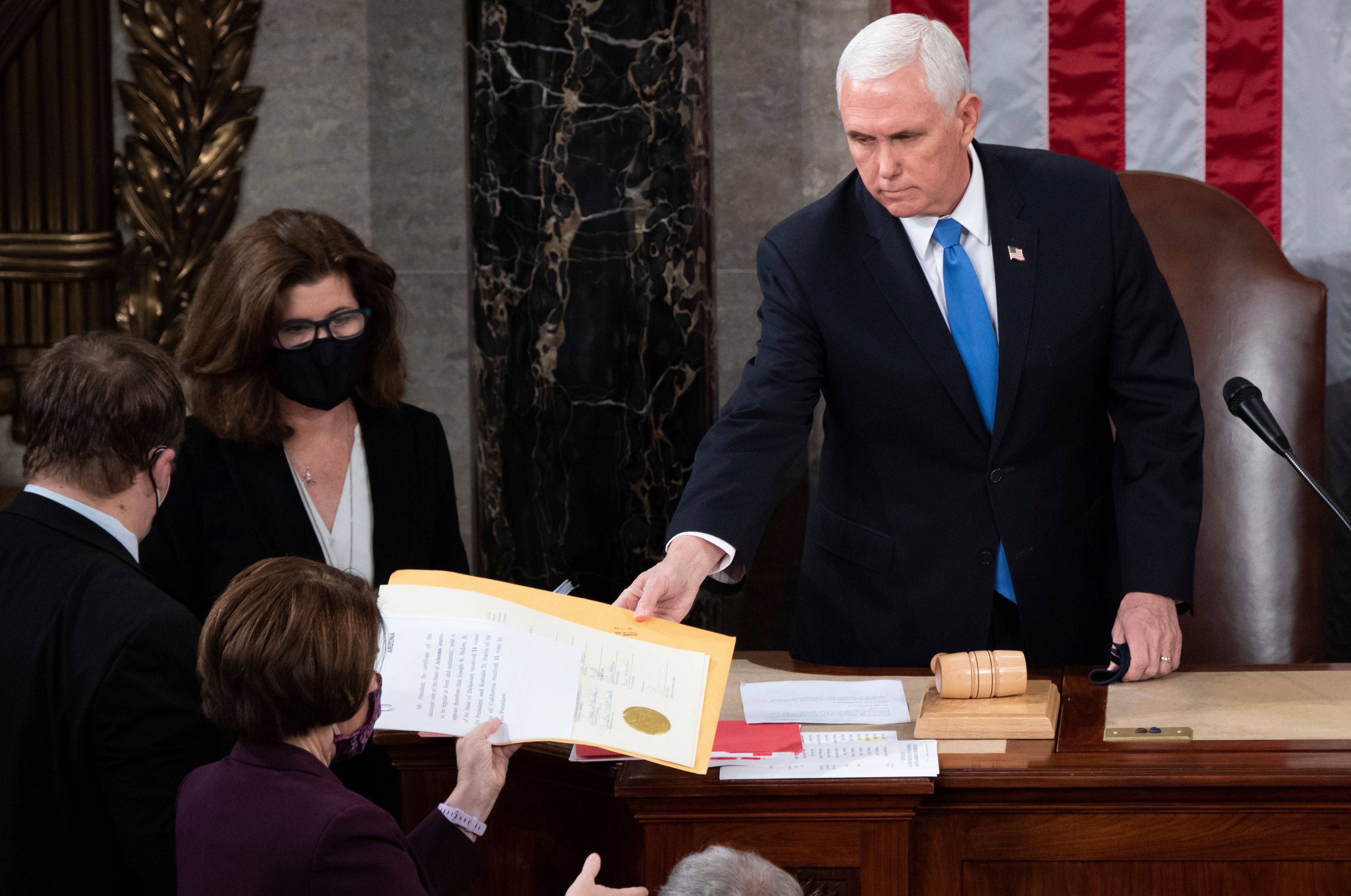 FILE - Vice President Mike Pence hands the electoral certificate from the state of Arizona to Sen. Amy Klobuchar, D-Minn., as he presides over a joint session of Congress as it convenes to count the Electoral College votes cast in November's election, at the Capitol in Washington, Jan. 6, 2021. (Saul Loeb/Pool via AP, File)