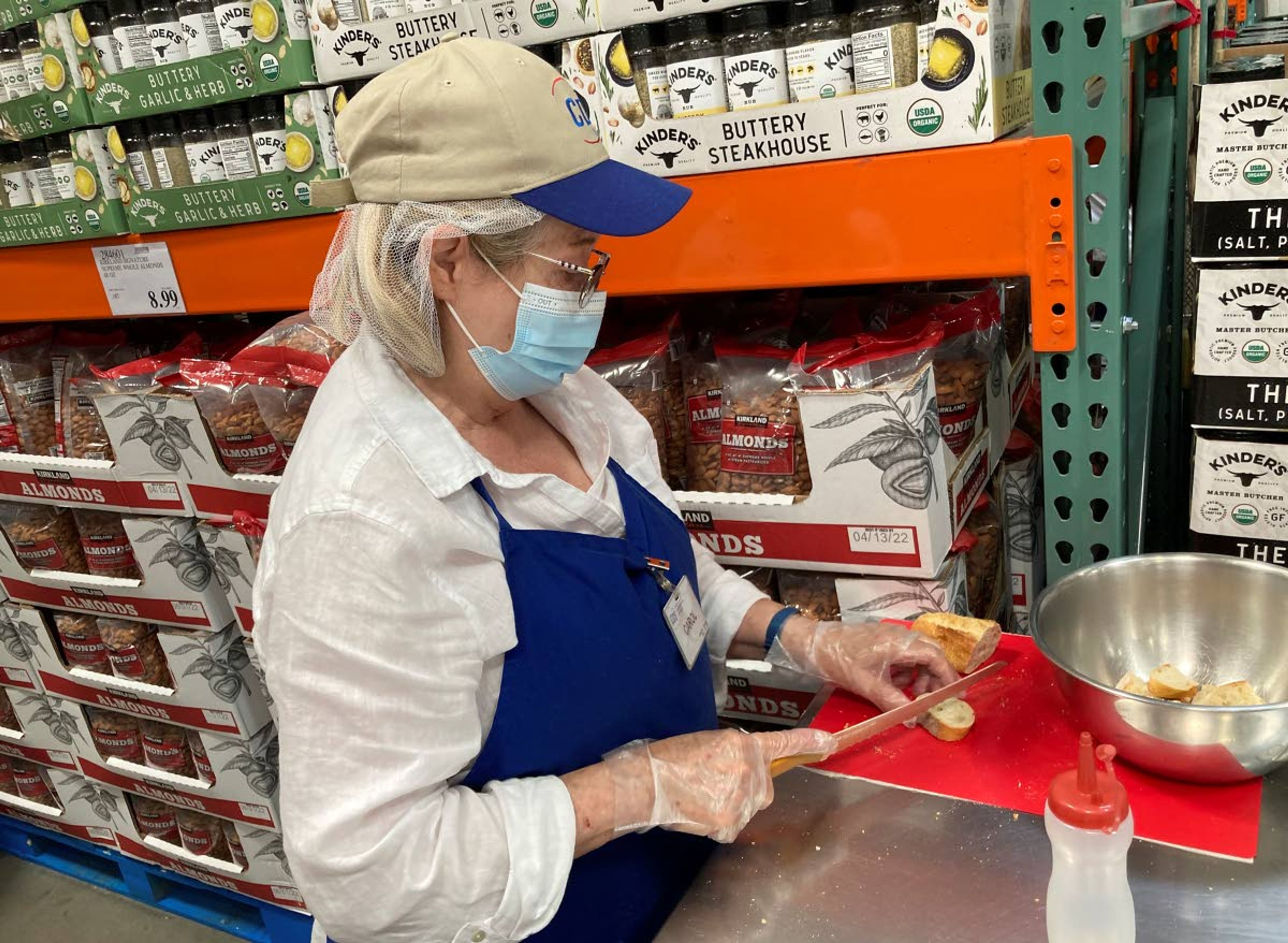 A worker prepares bread to offer as samples to shoppers June 17 in a Costco warehouse in Lone Tree, Colo.