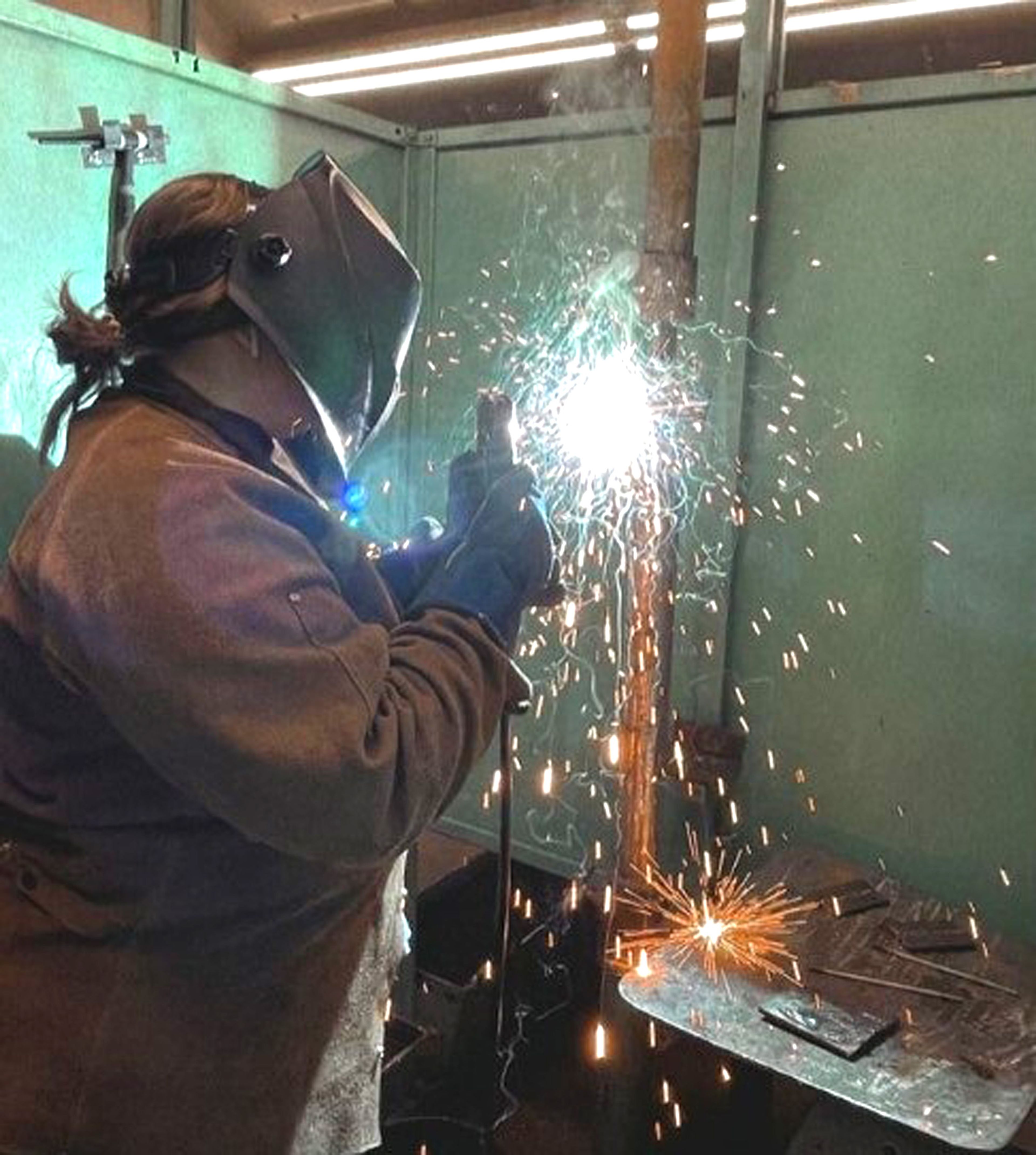 Shay Young, a senior agricultural major at the University of Idaho, works on a class project using an arc welder.