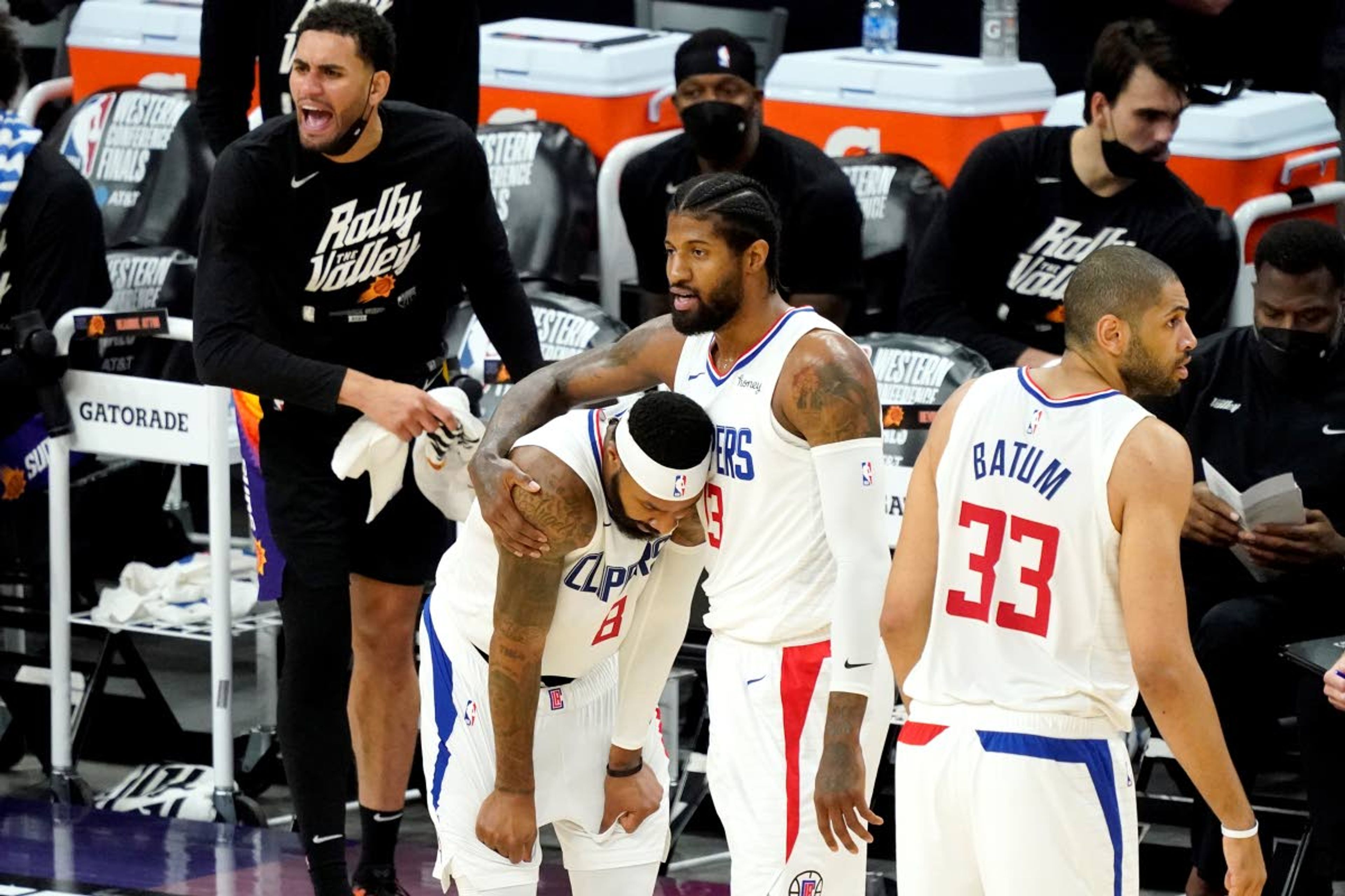 Los Angeles Clippers guard Paul George embraces Los Angeles Clippers forward Marcus Morris Sr., left, after a foul against the Phoenix Suns during the first half of game 5 of the NBA basketball Western Conference Finals, Monday, June 28, 2021, in Phoenix. (AP Photo/Matt York)