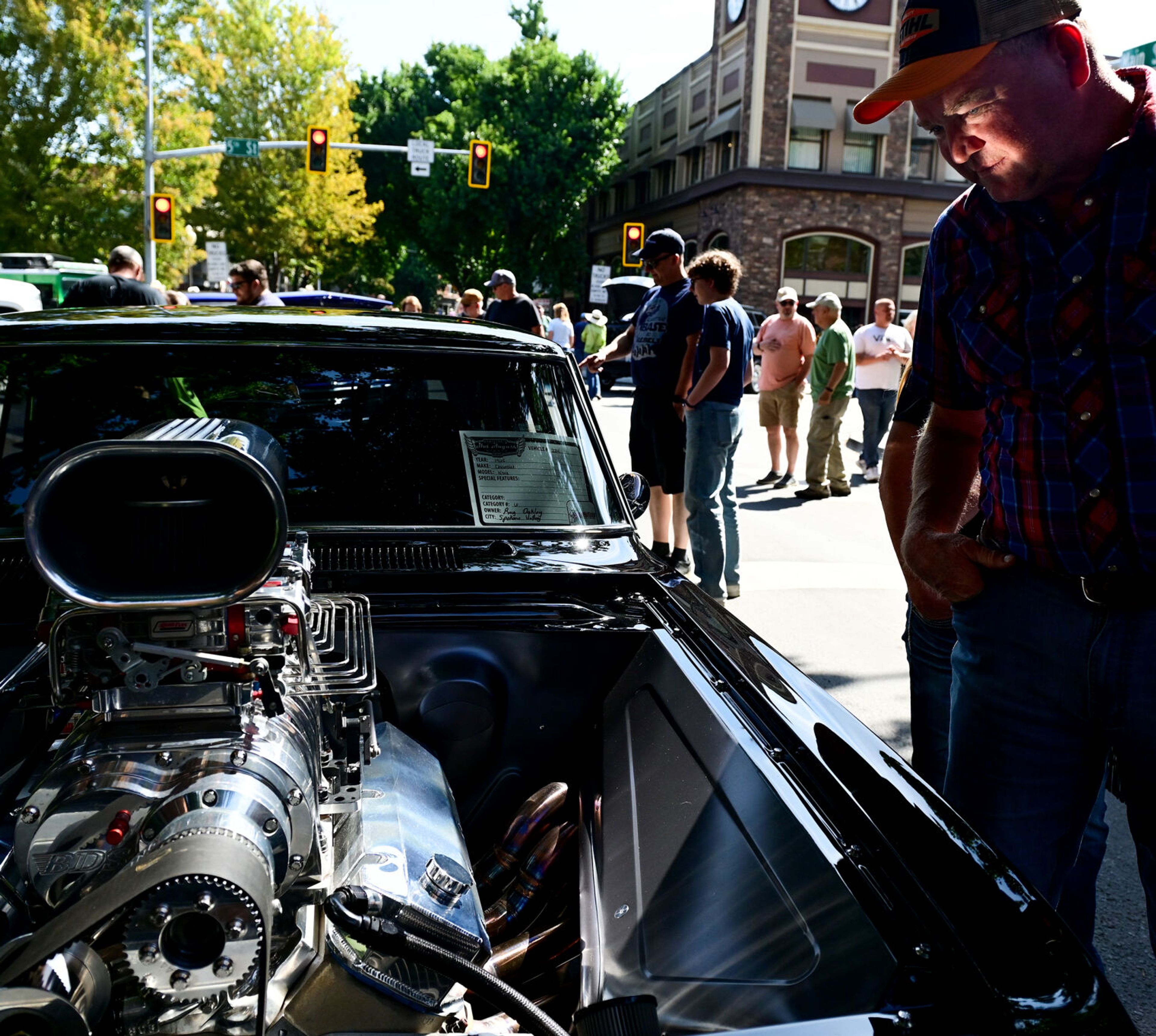 A 1965 Chevrolet Nova’s engine casts a reflective light on visitors at the Lewiston Hot August Nights car show on Saturday.