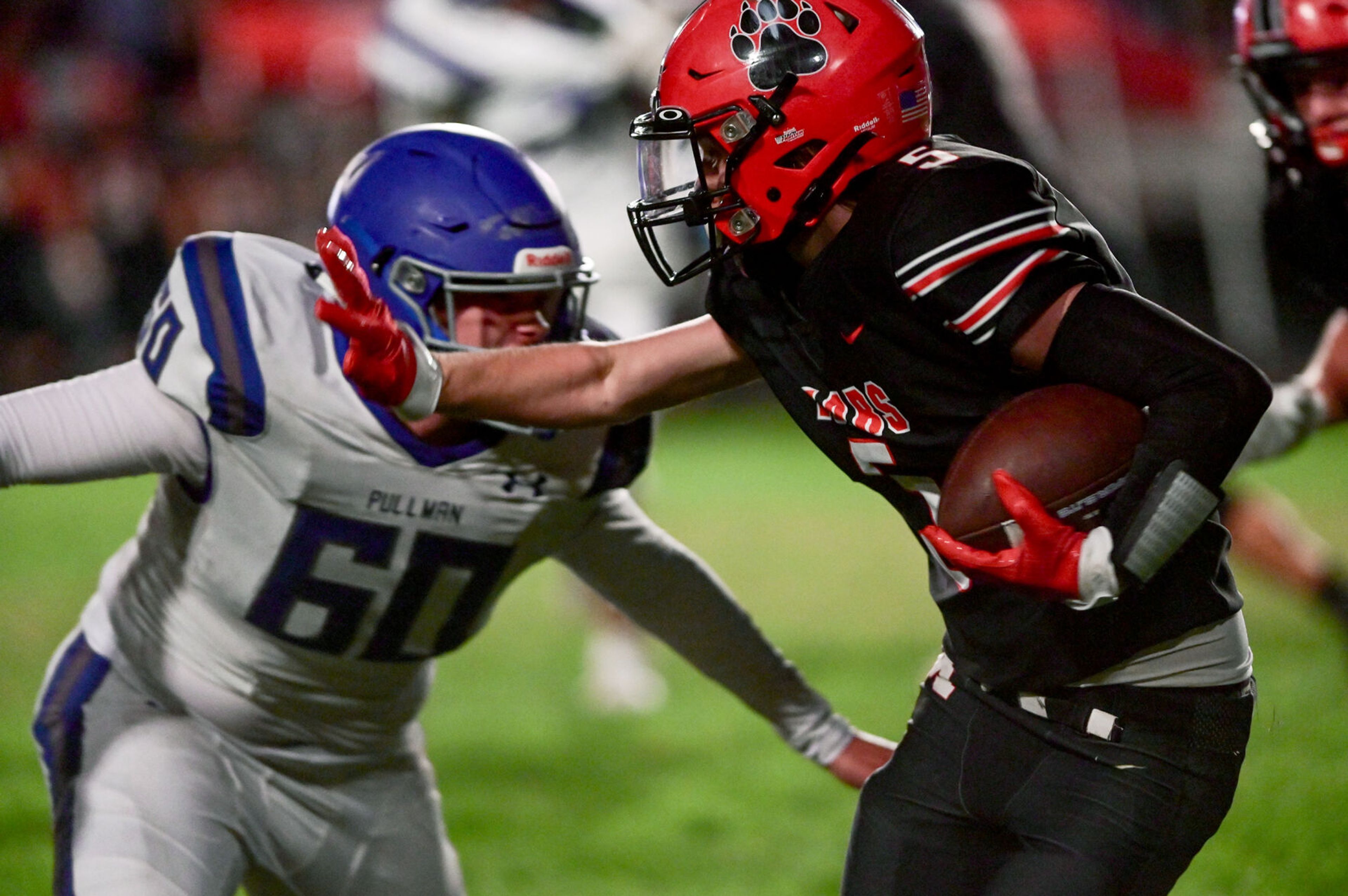 Moscow wide receiver Connor Isakson reaches an arm out in an attempt to protect from incoming defensive lineman Lucas Clark Friday in Moscow.