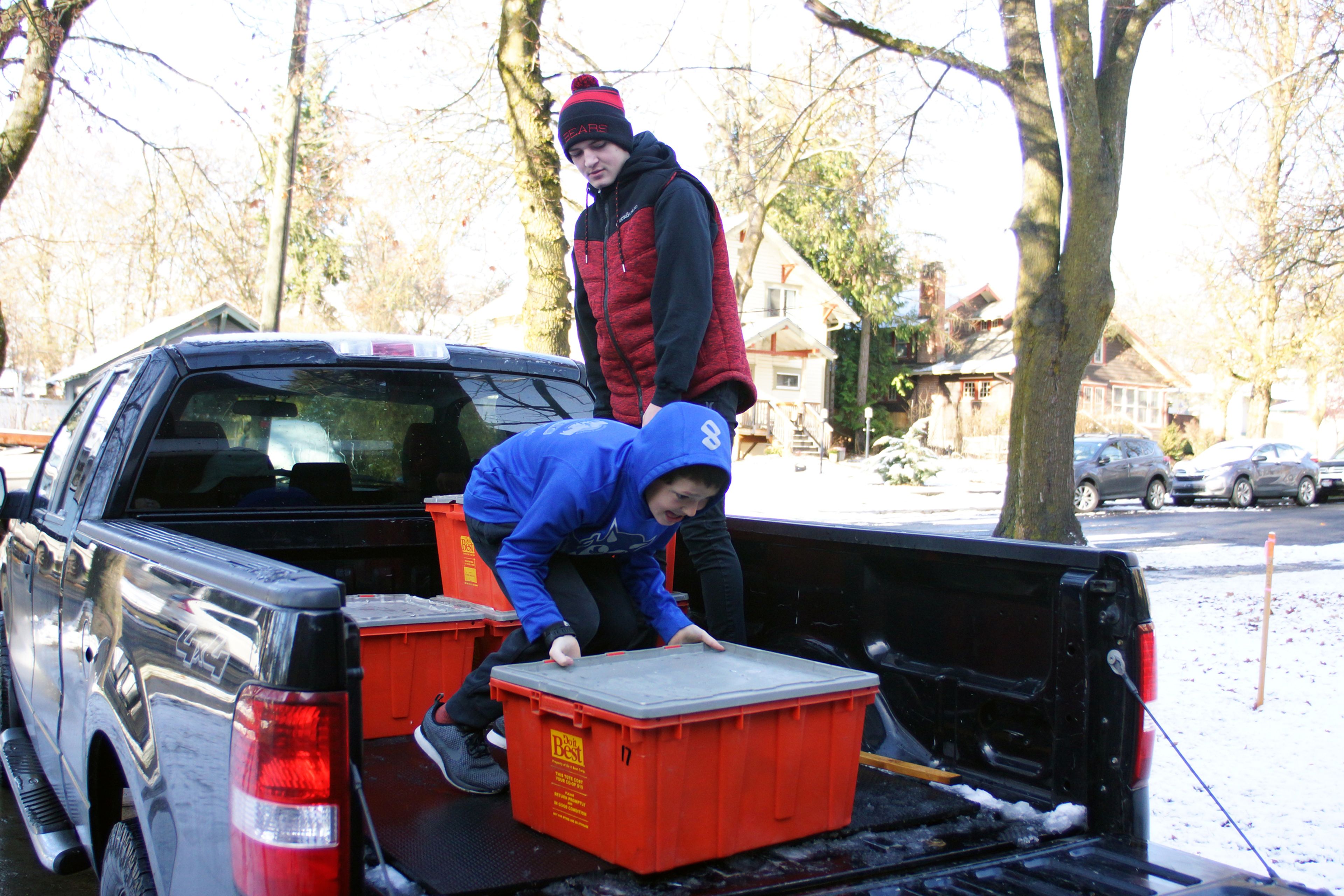 Michael Kiblen and younger brother Carter unload crates of food Saturday at the Moscow Food Bank  during the 13th annual Palouse Cares Food Drive and Auctions