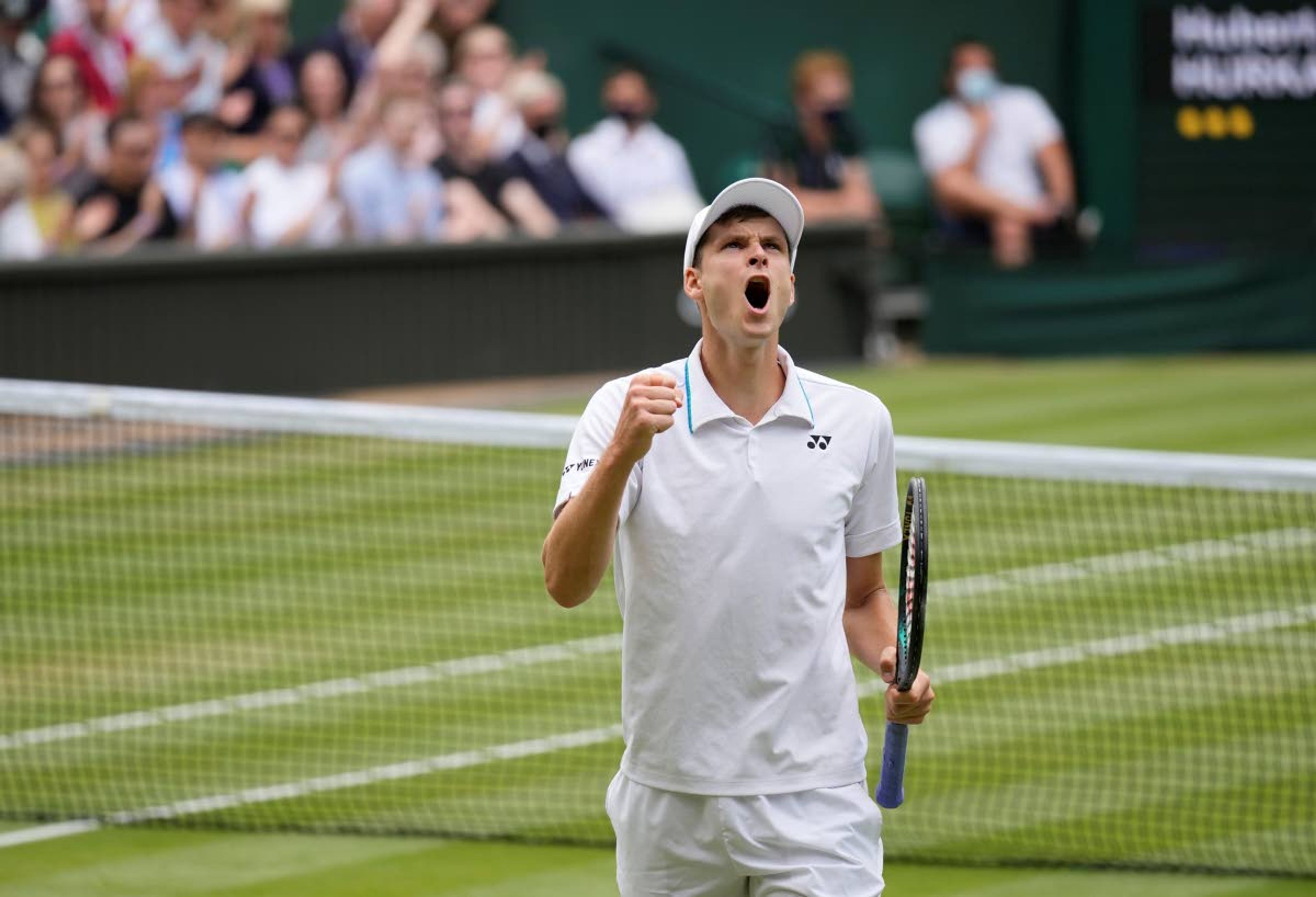 Poland's Hubert Hurkacz celebrates winning the third set against Italy's Matteo Berrettini during the men's singles semifinals match on day eleven of the Wimbledon Tennis Championships in London, Friday, July 9, 2021. (AP Photo/Kirsty Wigglesworth)