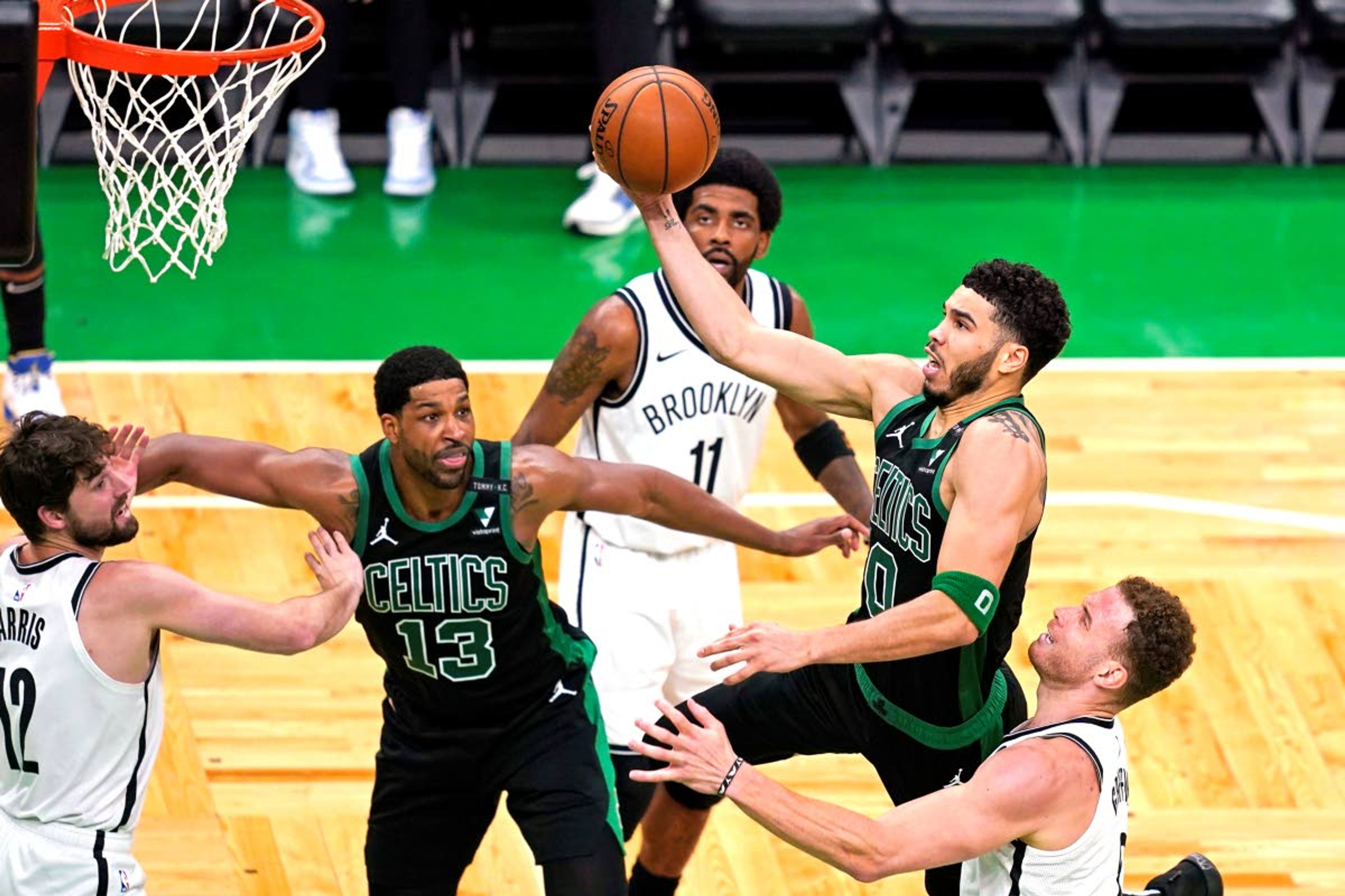 Associated PressCeltics forward Jayson Tatum drives to the basket past the Nets’ Blake Griffin, right, as Nets guard Kyrie Irving (11) and Celtics center Tristan Thompson watch during the third quarter of Game 3 in an NBA first-round playoff series Friday in Boston.