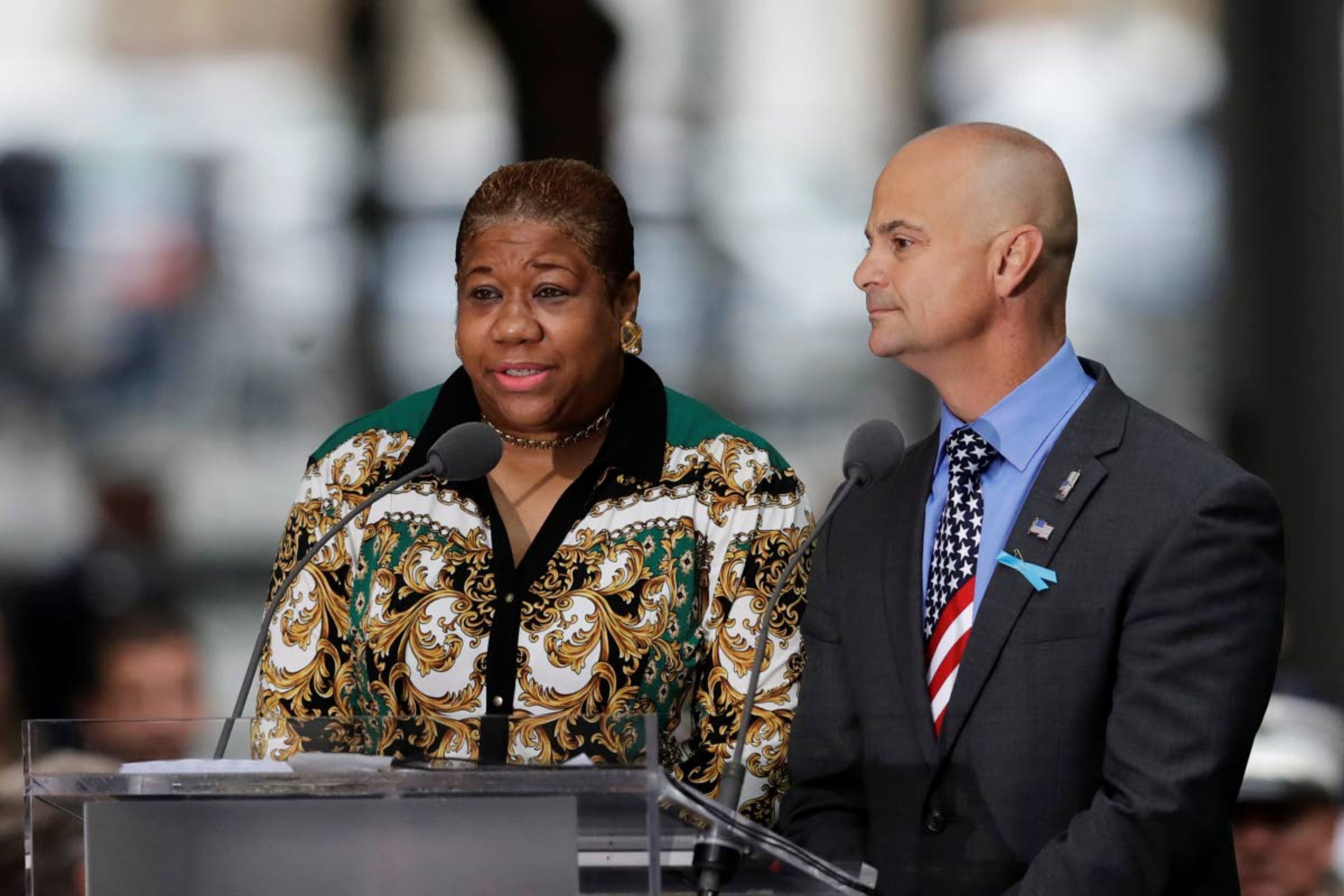 FILE - In this Sept. 11, 2018, file photo, La-Shawn Clark, left, and Mark Cannizzaro read names of victims of the Sept. 11 attacks during a ceremony marking the 17th anniversary in New York. Clark lost her husband, Benjamin Clark, and Cannizzaro lost his cousin, Brian Cannizzaro. The coronavirus pandemic has reshaped how the U.S. is observing the anniversary of 9/11. The terror attacks' 19th anniversary will be marked Friday, Sept. 11, 2020, by dueling ceremonies at the Sept. 11 memorial plaza and a corner nearby in New York. (AP Photo/Mark Lennihan, File)