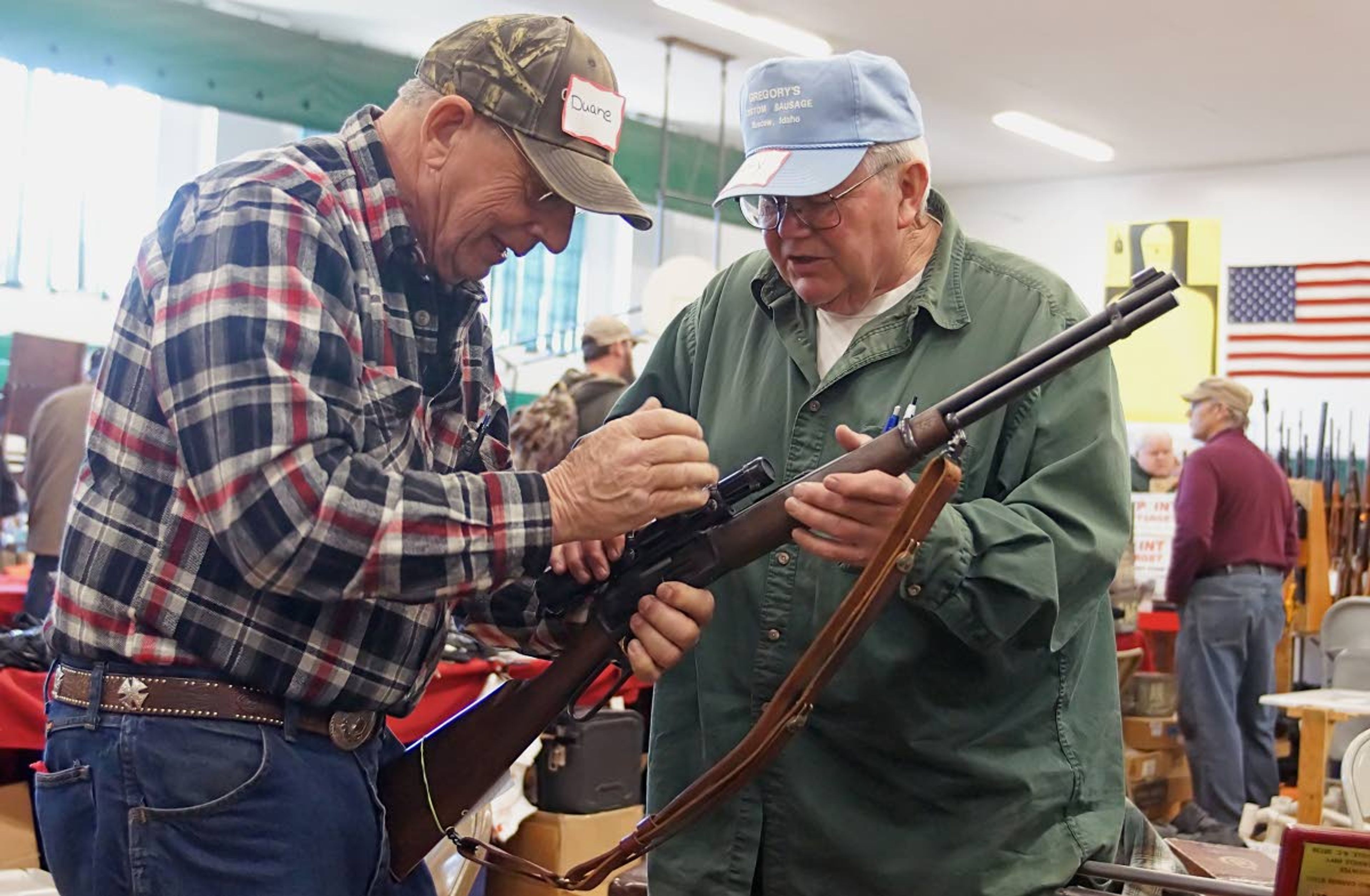 Potlatch Gun Show vendors Duane Owens, left, and Terry Gregory work at getting a scope taken off of a Marlin 30-30 Sunday afternoon.