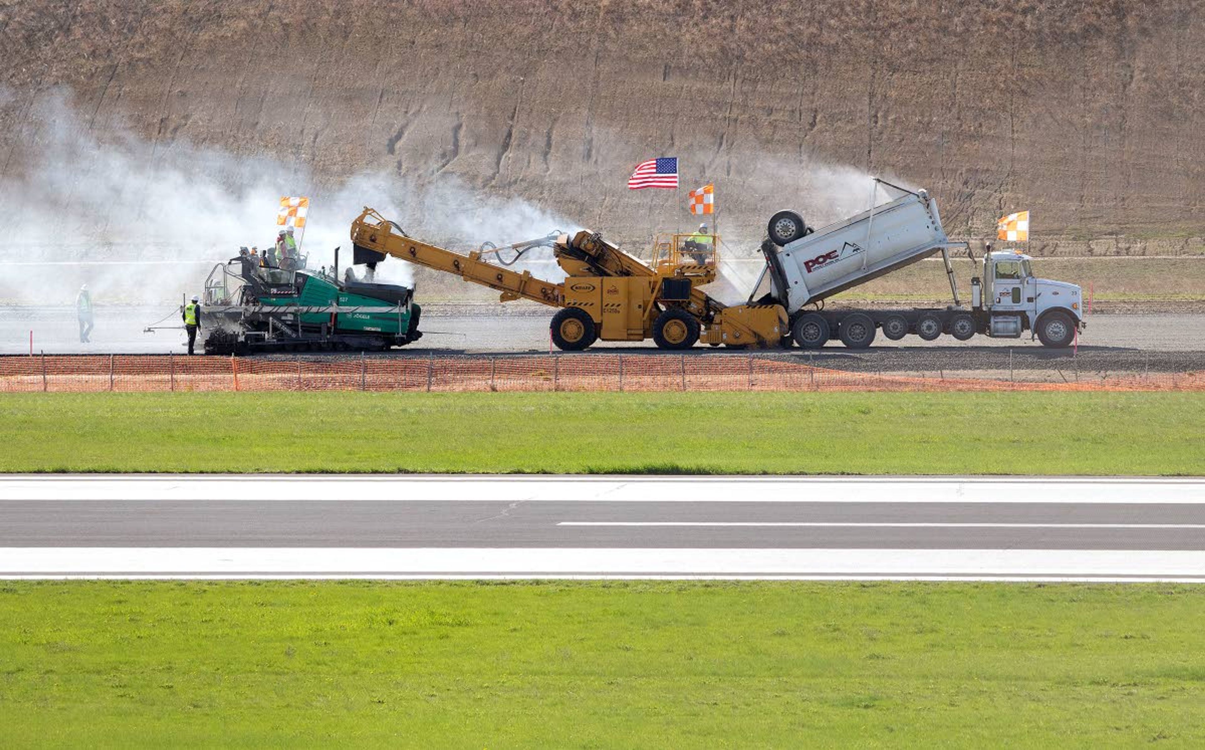 Geoff Crimmins/Daily NewsA crew from Poe Asphalt Paving begins paving the runway on Wednesday at the Pullman-Moscow Regional Airport. The paving machine will make 24 passes down the runway to lay 9 inches of asphalt in four layers. The existing runway will close Sept. 8, with the new runway scheduled to open on Oct. 4.