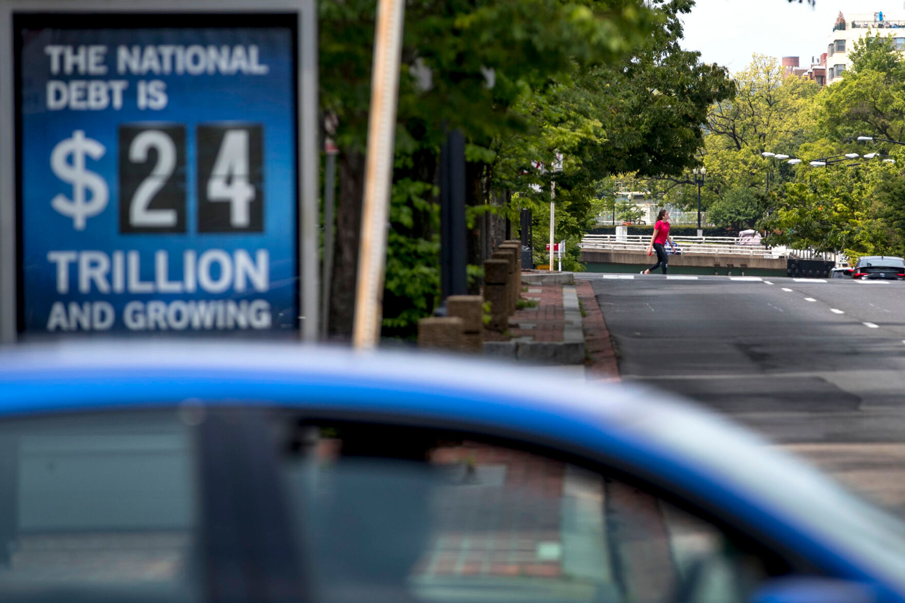 FILE - In this April 29, 2020 file photo, a sign displaying the size of the national debt is displayed along an empty K Street in Washington. The Congressional Budget Office has warned that the government this year will run the largest budget deficit, as a share of the economy, since 1945, the year World War II ended. Next year, the federal debt — made up of the year-after-year gush of annual deficits — is forecast to exceed the size of the entire American economy for the first time since 1946. (AP Photo/Andrew Harnik, File)