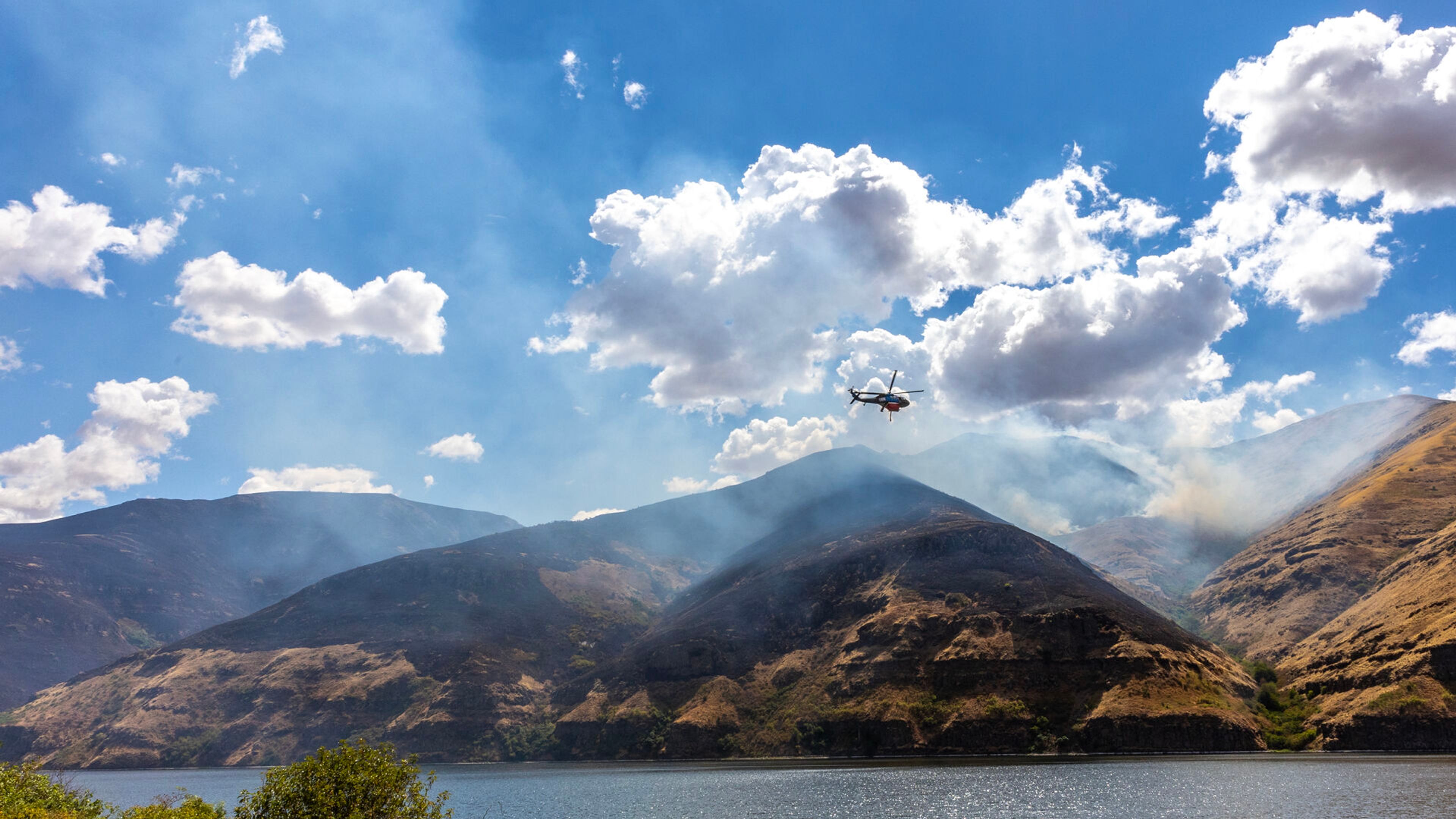 A helicopter flies towards the Lower Granite Fire Tuesday off the Snake River.