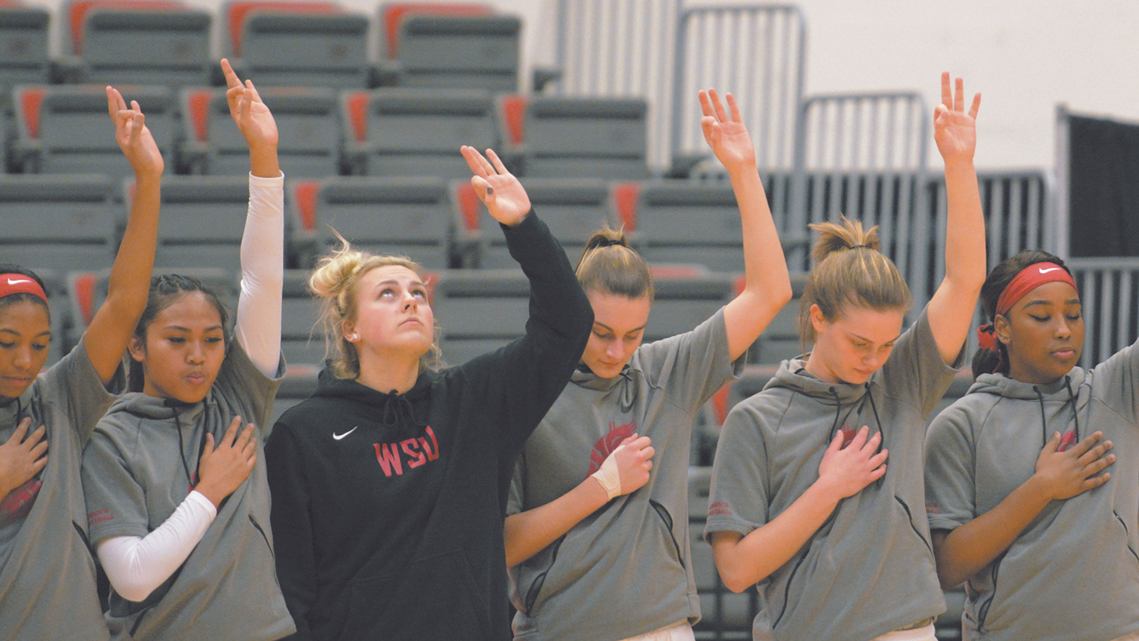 Washington State players hold up the three fingers in honor of Tyler Hilinski during a moment of silence to honor the 21-year-old prior to the start of the first half of a PAC-12 Conference basketball game against Washington, Wednesday, Jan. 17, 2018, in Pullman, Wash.