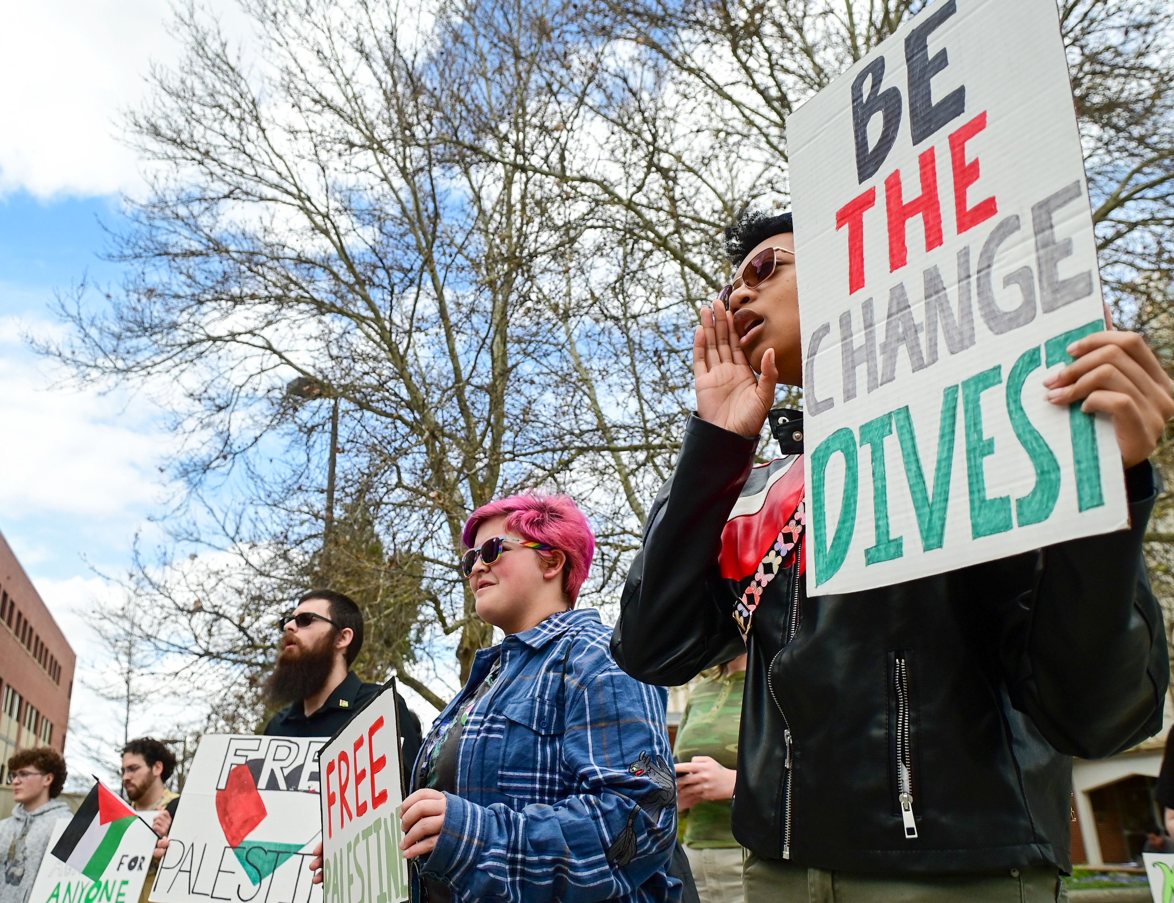 Those gathered outside of the University of Idaho Library in Moscow on Thursday for a pro-Palestine demonstration hold posters and listen to speakers, including UI freshmen Basil Hennes, center, and Autumn Austin.