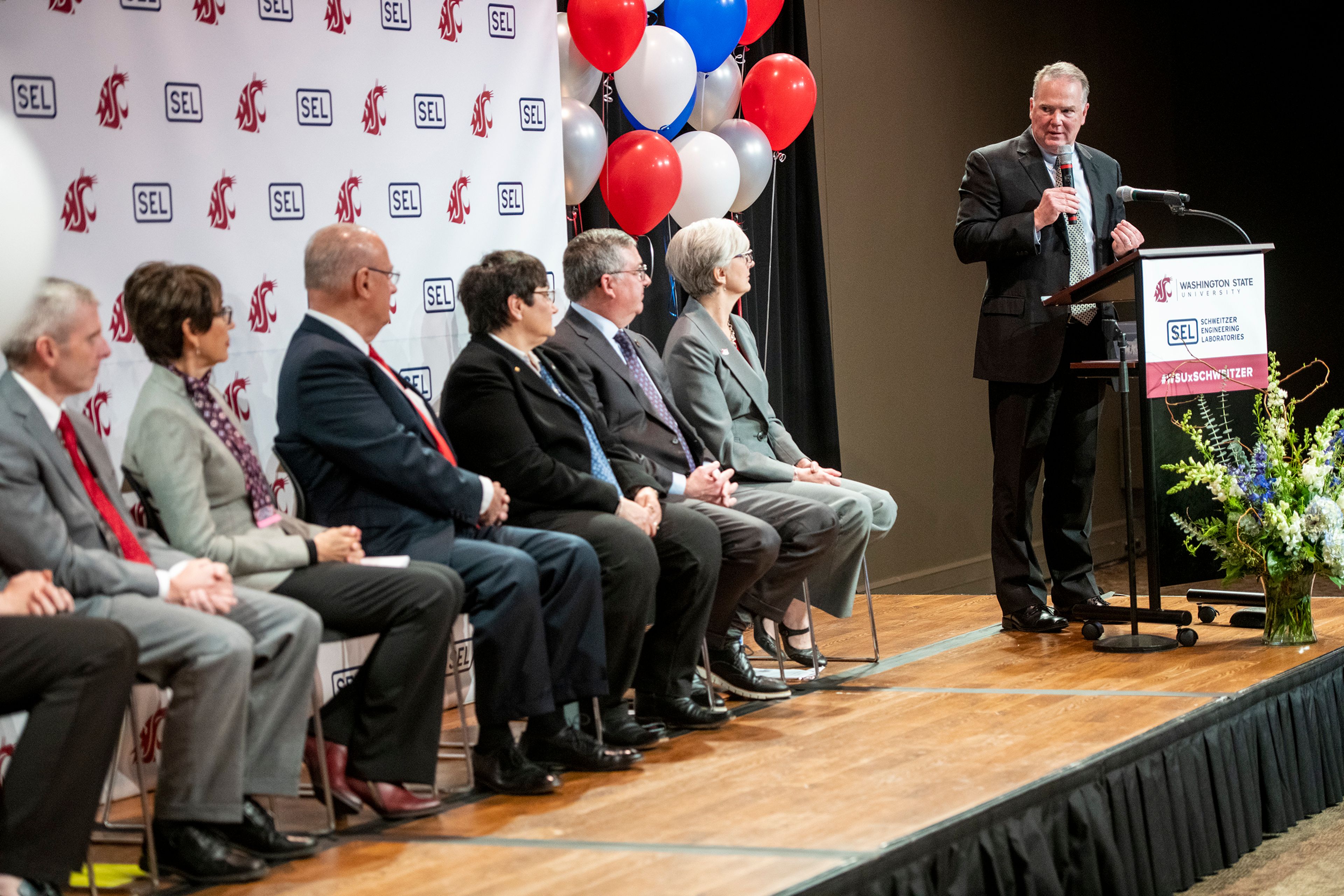 Mike Connell, Vice President of Washington State University Advancement and CEO of the WSU Foundation, speaks to Dave Whitehead, from left, Beatriz Schweitzer, Ed Schweitzer, Noel Schulz, Kirk Schulz and Mary Rezac during an announcement of a combined $20 million donation to WSU from Schweitzer Engineering Laboratories and the Schweitzers.