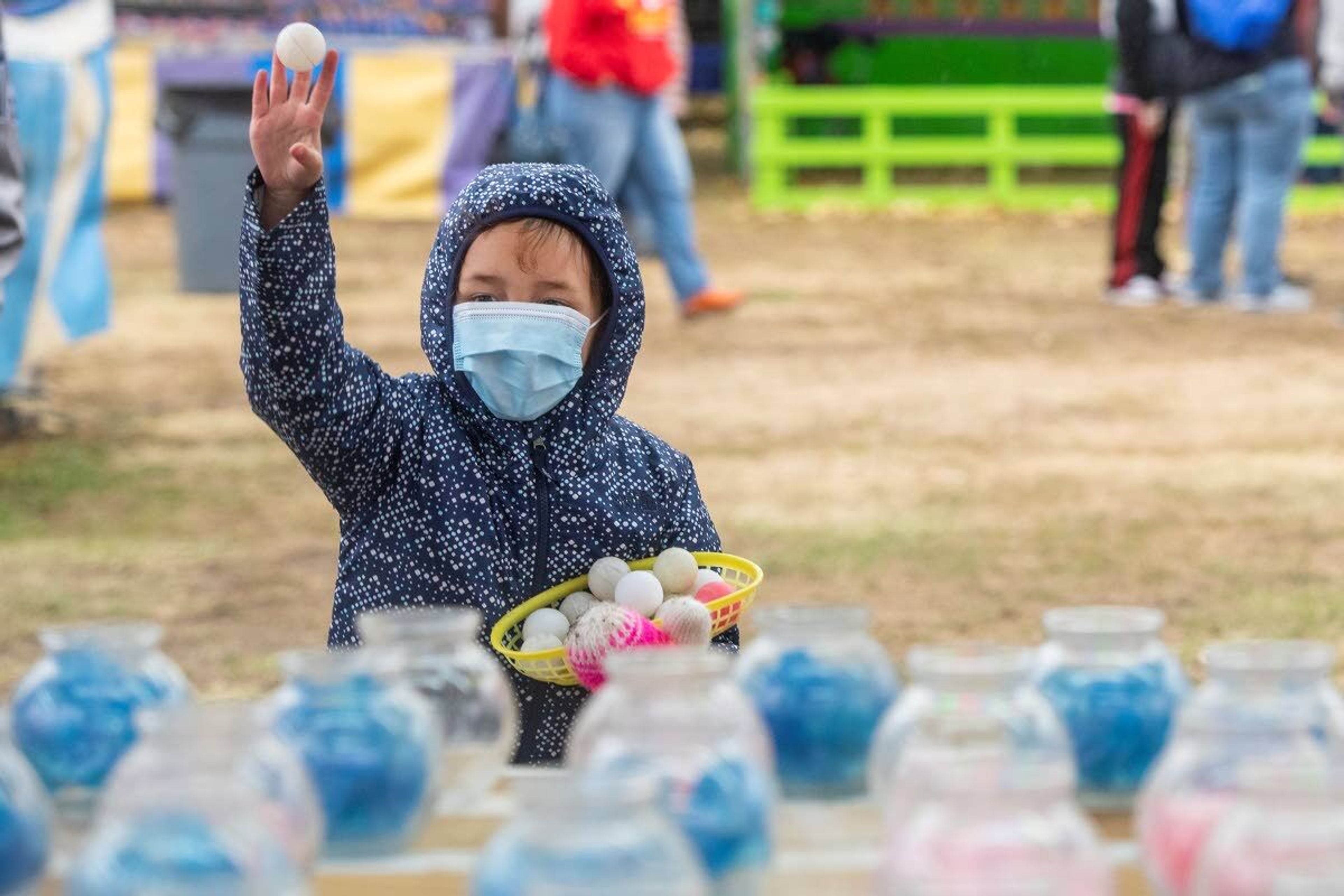 Kinsley Castro, 5, tosses a ping pong ball as she tries to make it into a fish bowl to win a prize while visiting the Latah County Fair with her parents, Jay and Jamie Castro, on Saturday morning in Moscow.