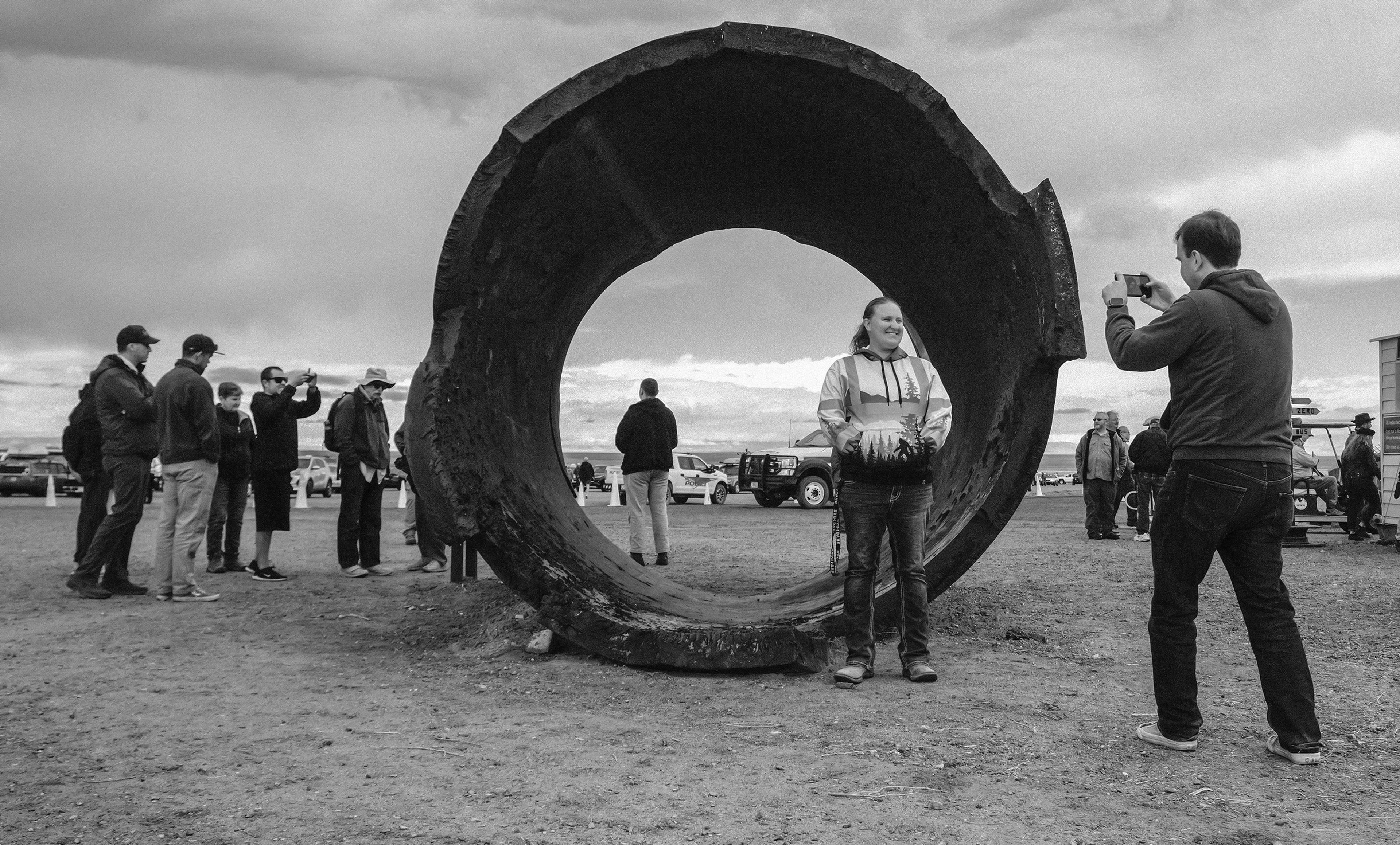 Visitors get their photo taken in front of the remains of the 200 ton Jumbo, a not-used steel containment vessel, blown up later in a non-nuclear test.,