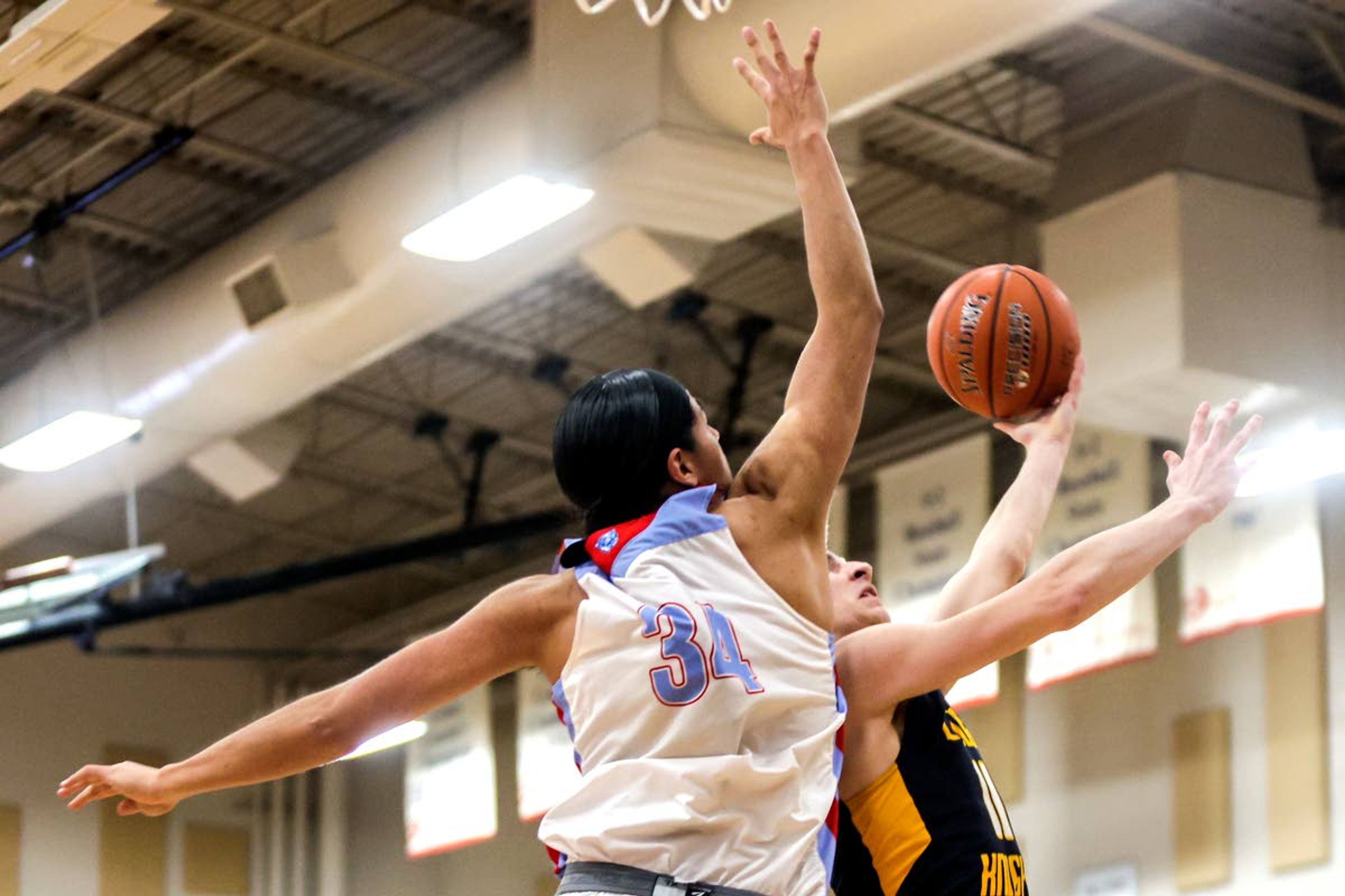 Logos Roman Nutbrock goes up for a shot as Lapwai forward Alexander Ellenwood guards him during round two of the Idaho High School boys state basketball tournament at Vallivue High School on Friday.