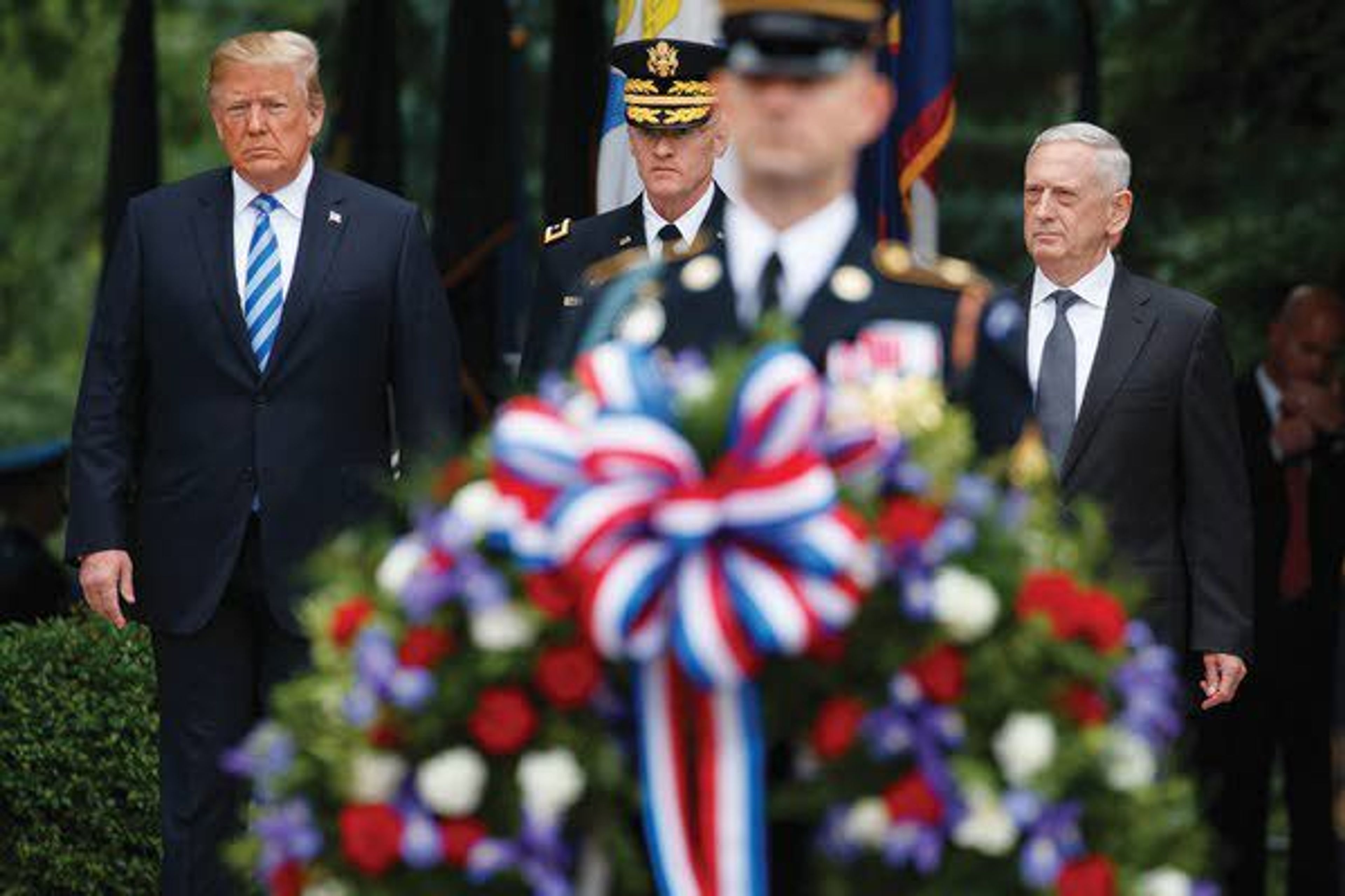 President Donald Trump, left, Maj. Gen. Michael L. Howard, commanding general of Joint Force Headquarters-National Capital Region and the Military District of Washington, center, and Secretary of Defense Jim Mattis arrive for a Memorial Day wreath laying ceremony at Arlington National Cemetery on Monday in Arlington, Va.