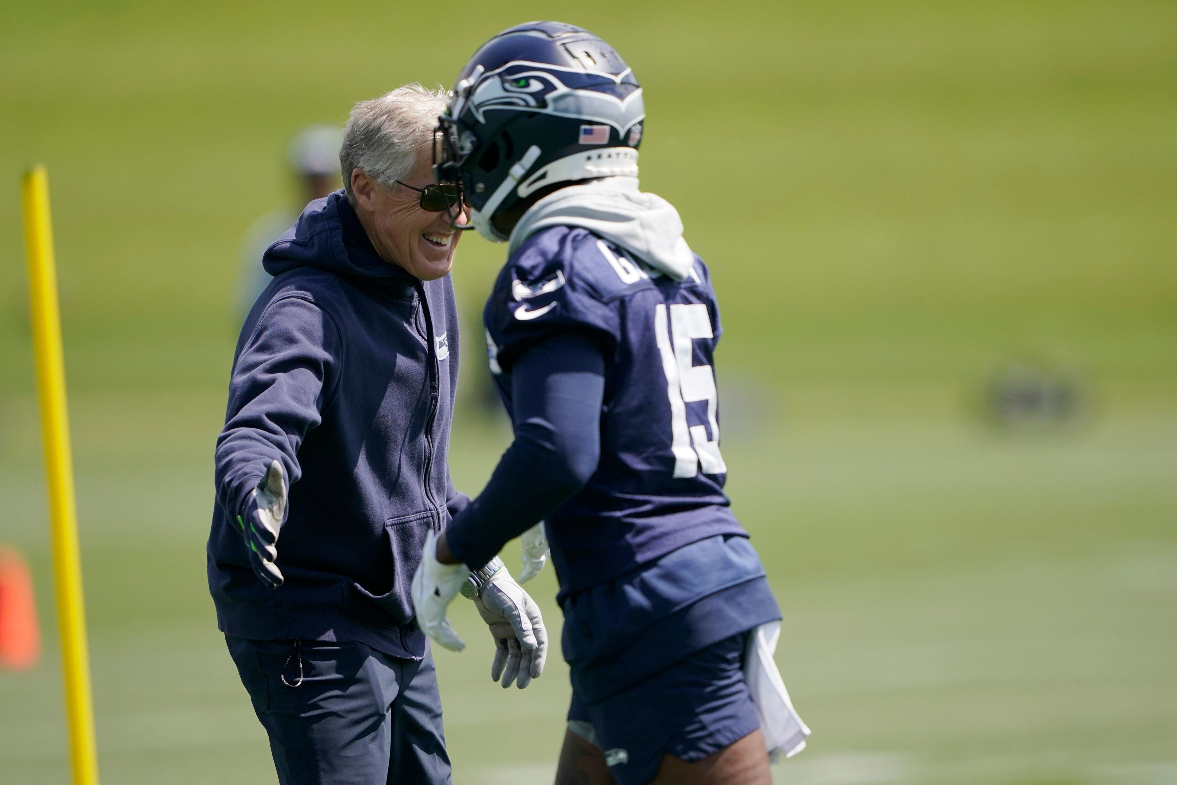 Seattle Seahawks wide receiver Marquise Goodwin (15) is greeted by head coach Pete Carroll, left, during NFL football practice Monday, May 23, 2022, in Renton, Wash. (AP Photo/Ted S. Warren)