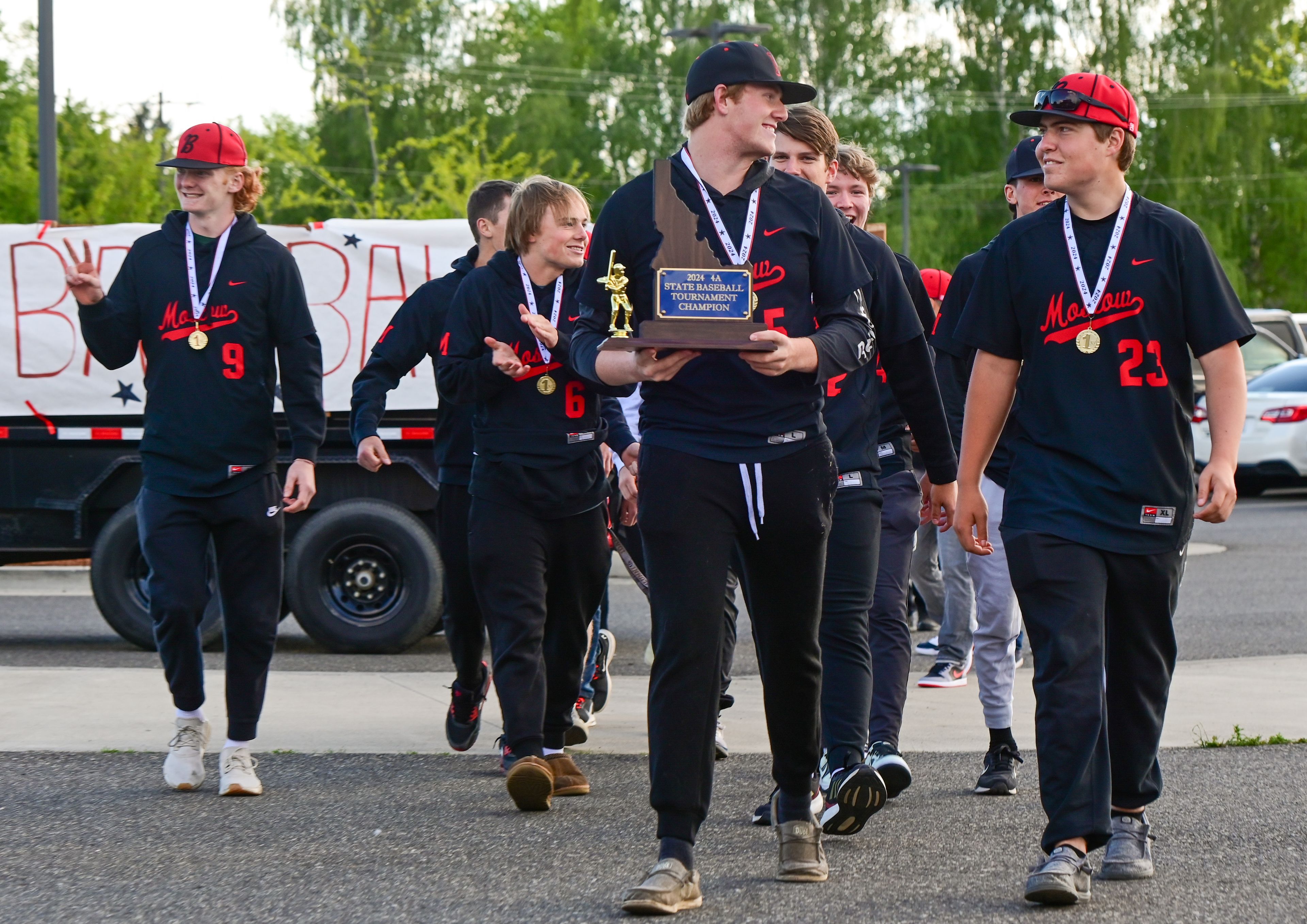 Moscow baseball players carry their state championship trophy as they arrive at the Moscow Playfields to the applause of community members celebrating their win in Moscow on Thursday.