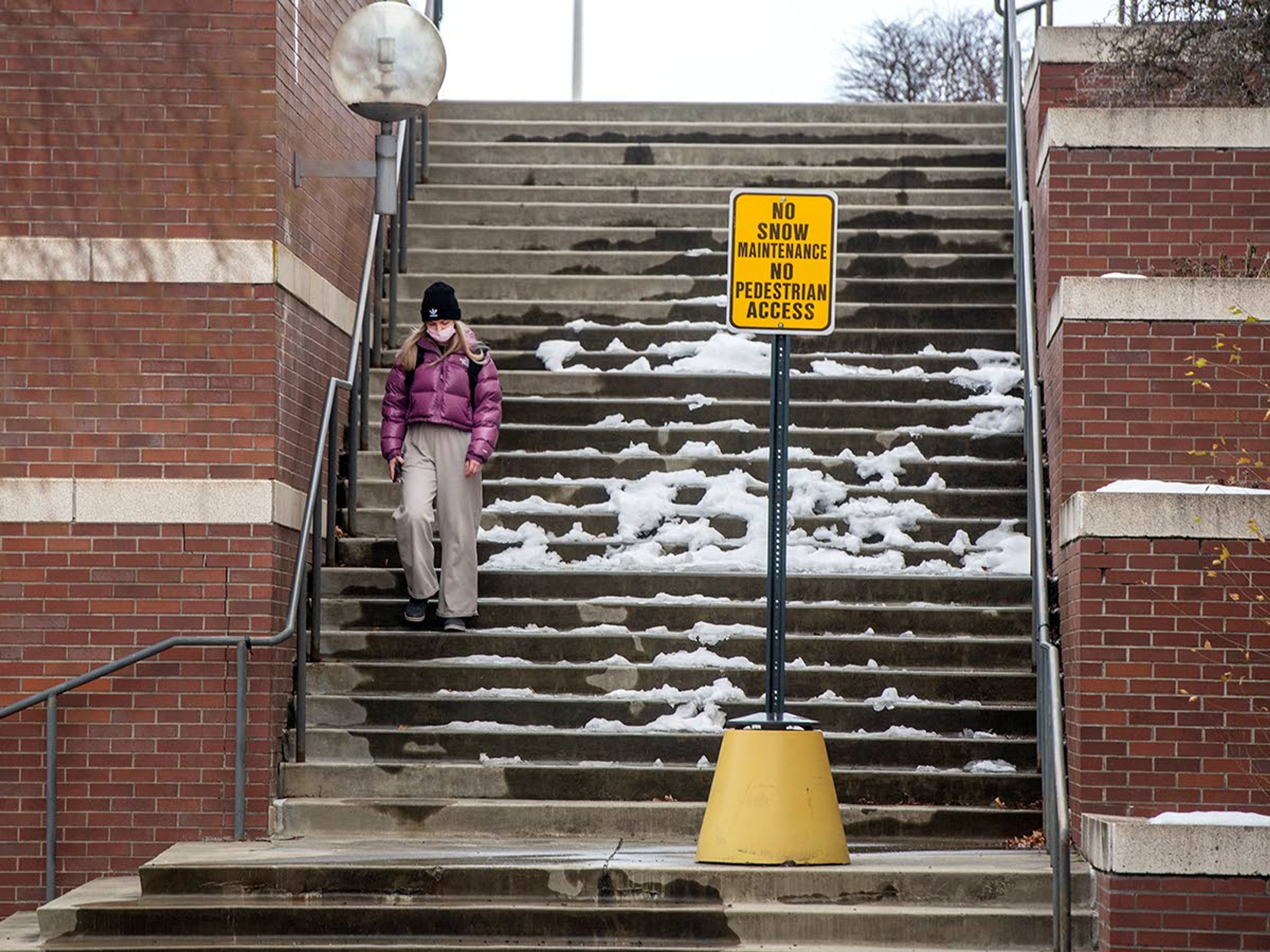 A student walks down steps covered in melting ice Wednesday as spring classes begin at Washington State University in Pullman.