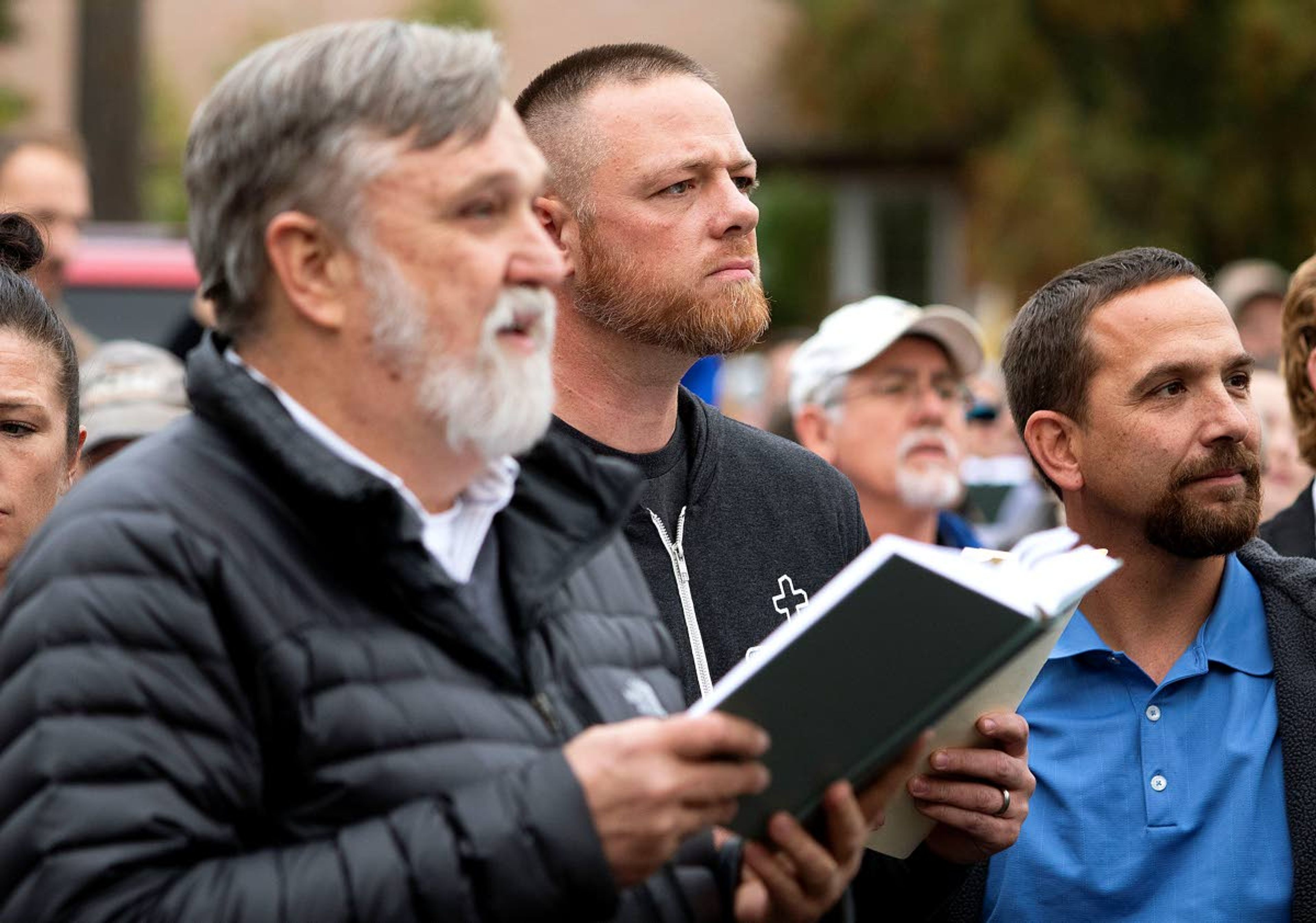 Christ Church Pastor Doug Wilson, center, and Latah County Commission candidate Gabriel Rench, center, sing a hymn over the noise from counter-protesters playing drums during “psalm sing” on Friday outside Moscow City Hall.