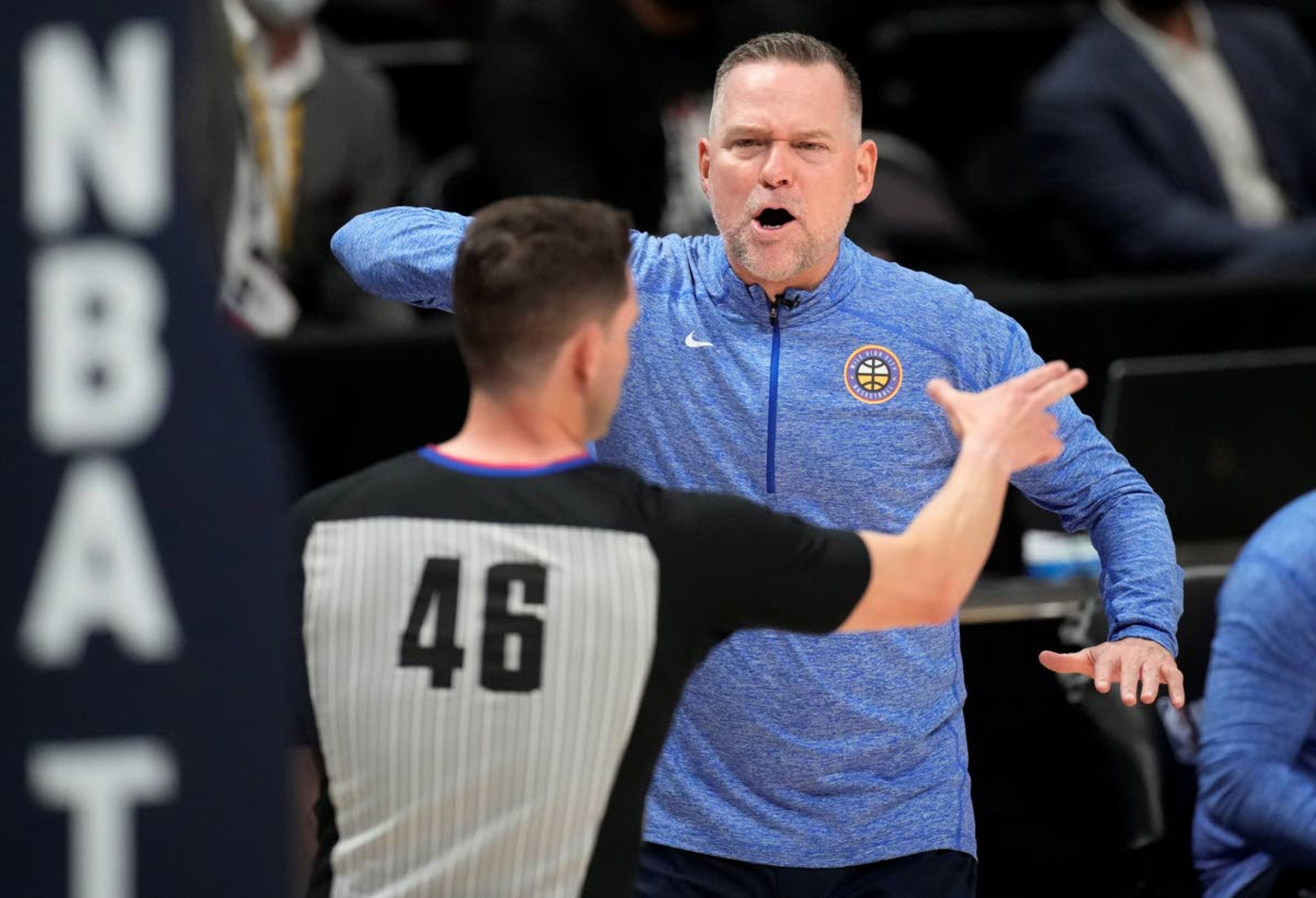 Denver Nuggets coach Michael Malone, back, makes a point to referee Ben Taylor during the second half of Game 3 of the team's NBA second-round playoff series against the Phoenix Suns on Friday, June 11, 2021, in Denver. (AP Photo/David Zalubowski)