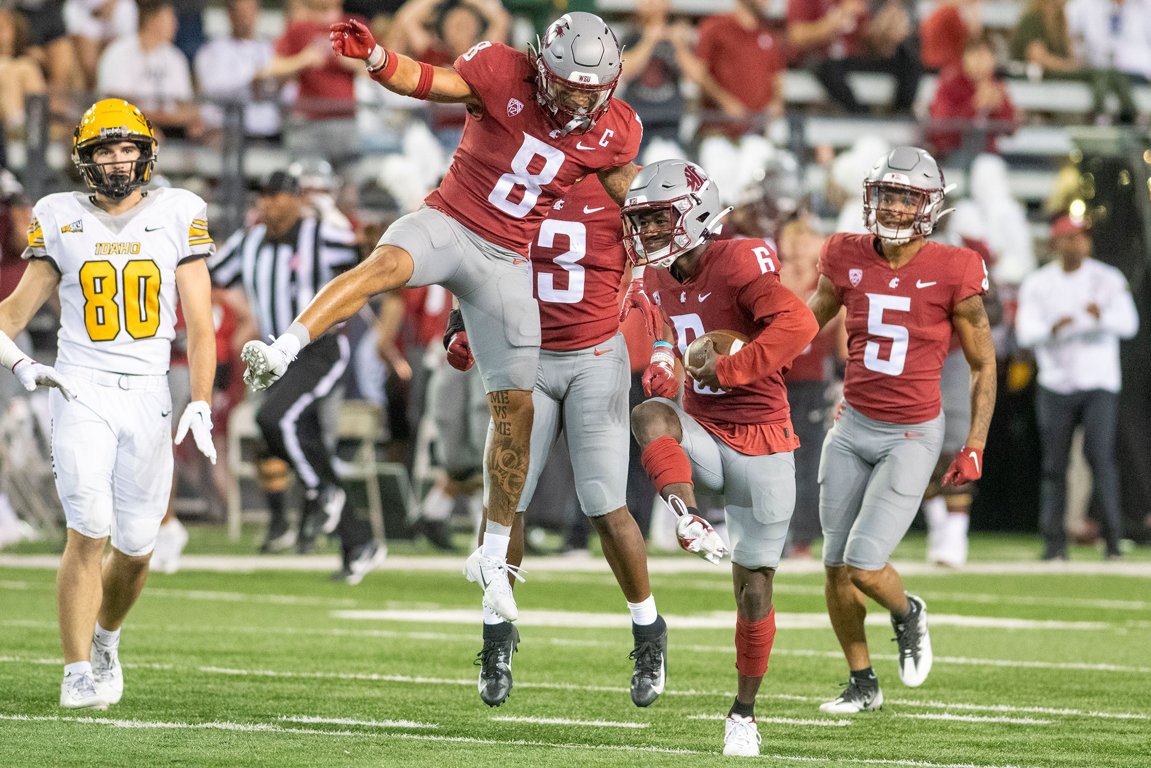 Washington State Cougars celebrate after Washington State Cougars defensive back Chau Smith-Wade (6) intercepted a pass during the second quarter of the Battle of the Palouse football game in Pullman on Saturday.