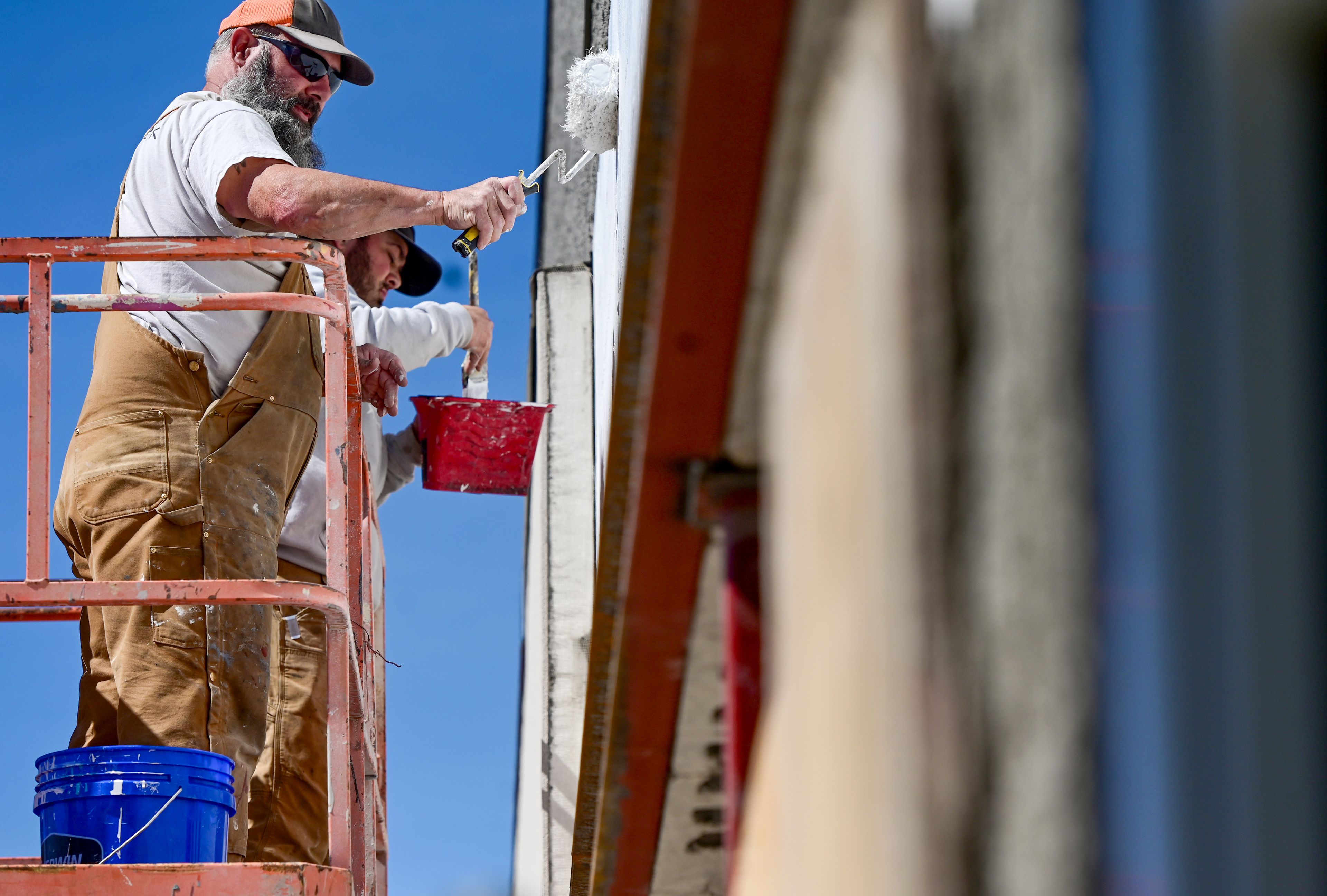 A crew with Jefferson Land & Development on Monday works to paint the outside of a space between Target and Great Clips at the Palouse Mall in Moscow.