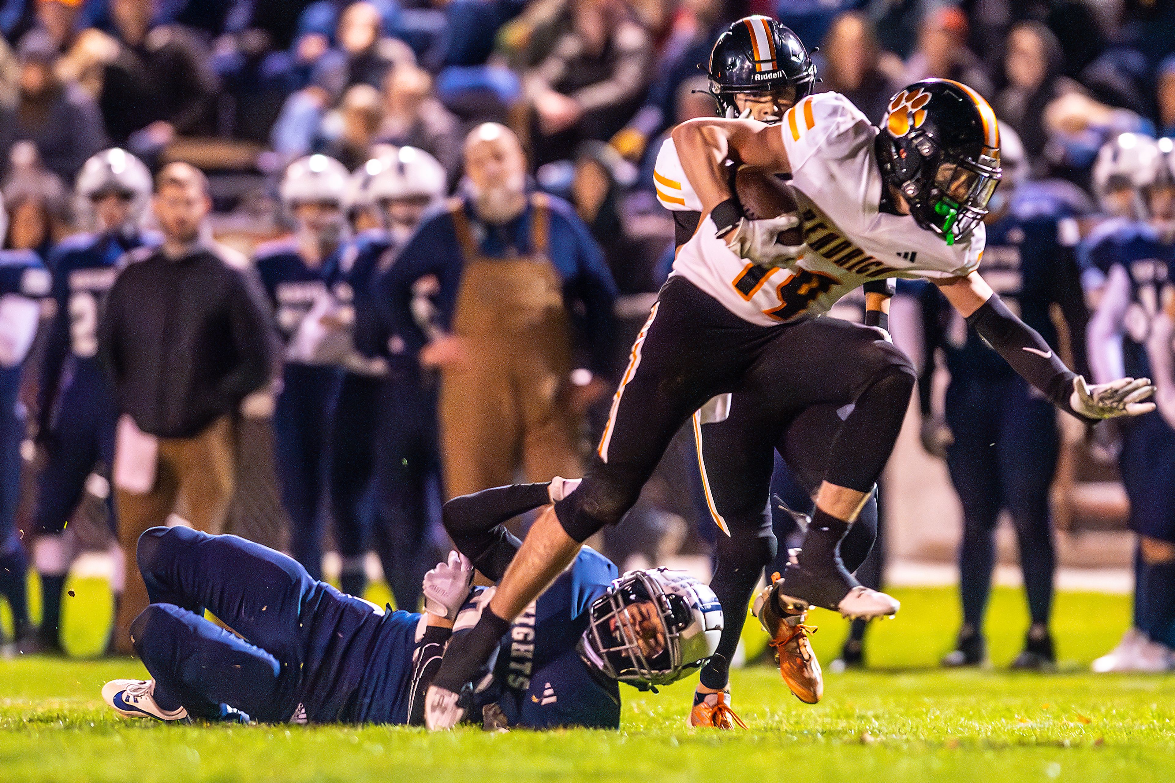 Kendrick running back Sawyer Hewett runs the ball as Logos cornerback Max Hawthorne hits the ground in a semifinal game of the Idaho State Football Class 2A Championships Friday at Bengal Field in Lewiston.