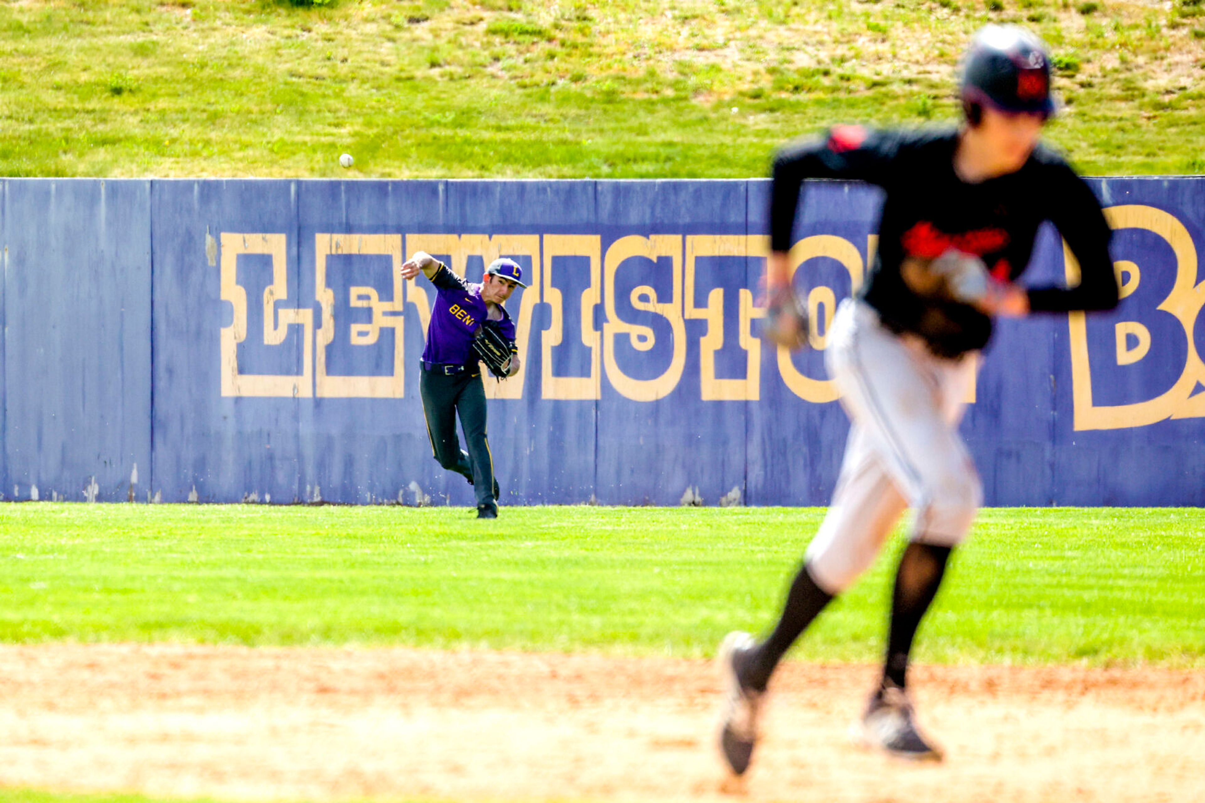 Lewiston’s Zachary Lombard throws towards the infield as Moscow’s Cody Isakson returns to first base at Church Field on Saturday. Lewiston defeated Moscow 6-4.