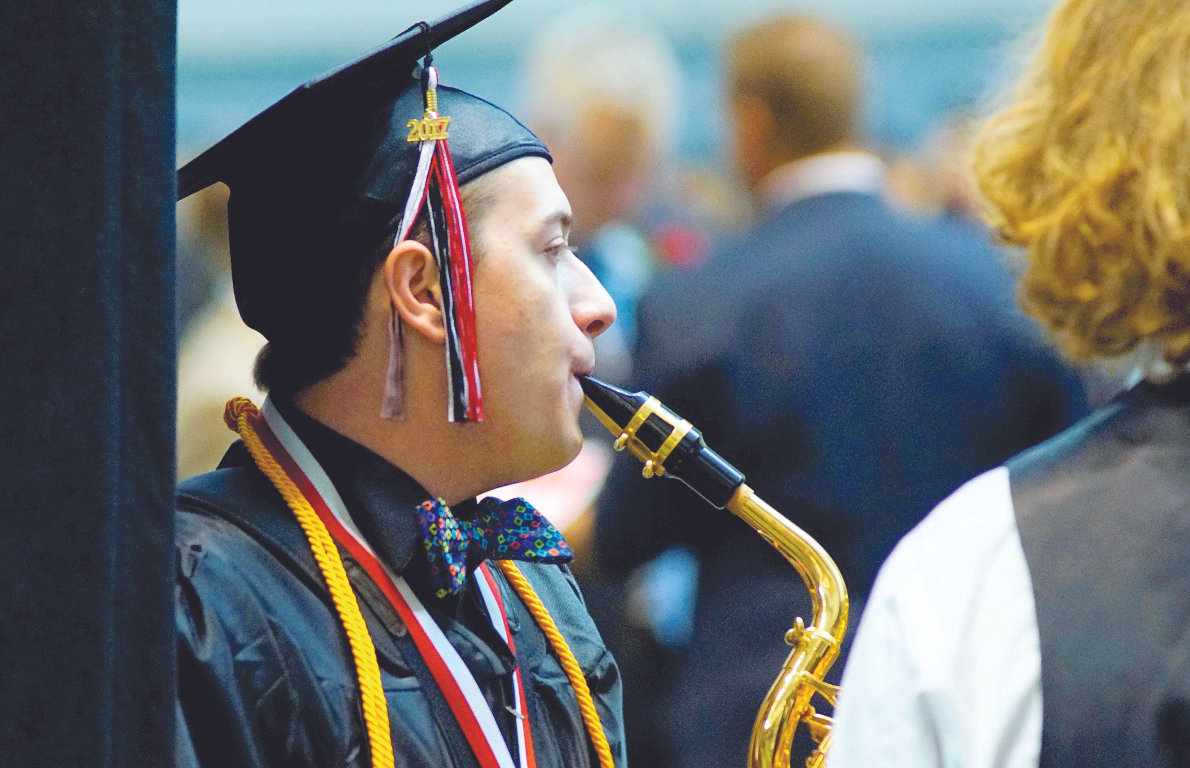 Timothy Malm warms up with his saxaphone before playing with the Moscow High School band for the last time before the school's commencement ceremony Friday evening in the Kibbie Dome.