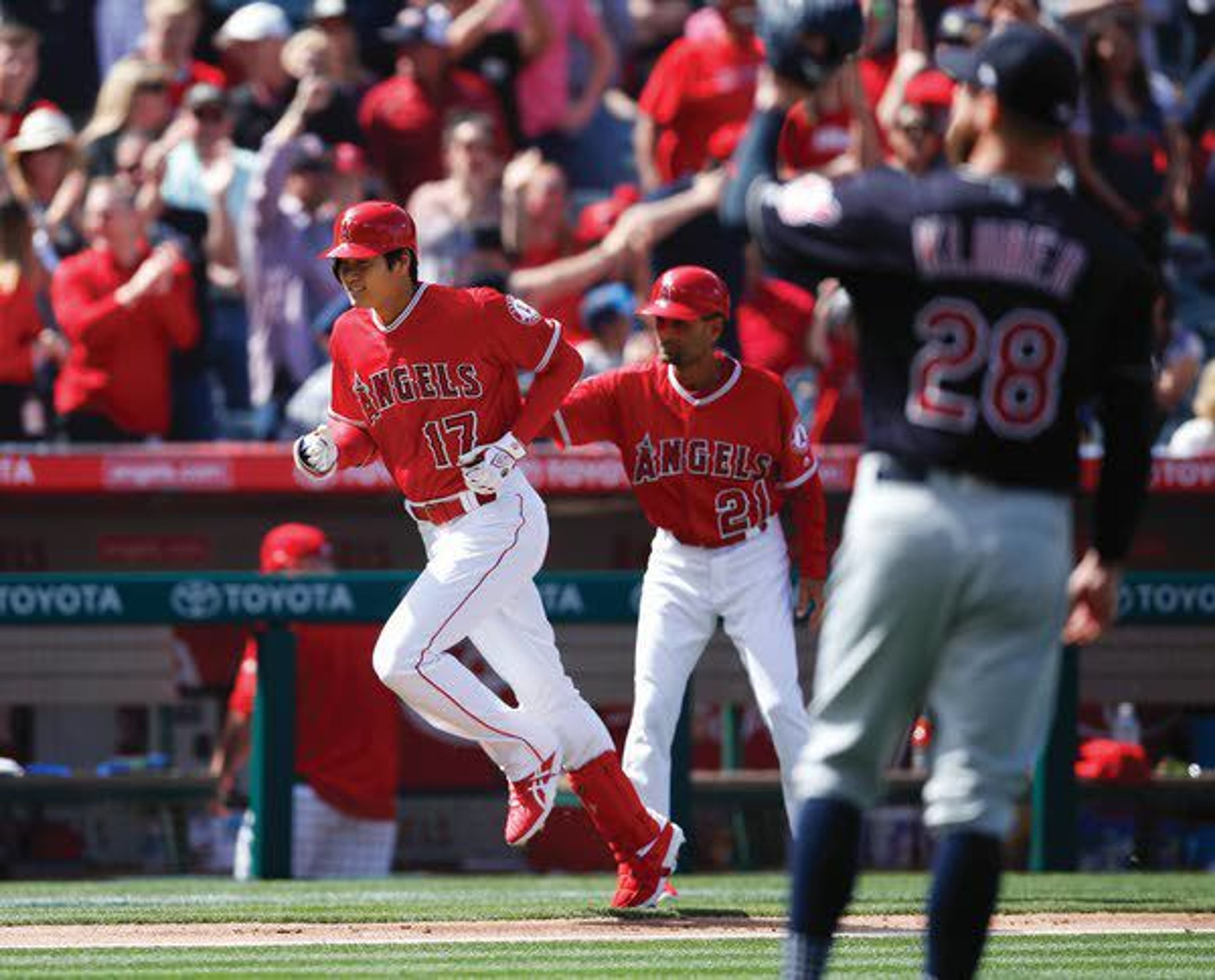 Angels' Shohei Ohtani, left, of Japan, is congratulated by third base coach Dino Ebel after hitting a two-run home run against Indians starting pitcher Corey Kluber during the fifth inning Wednesday in Anaheim, Calif.