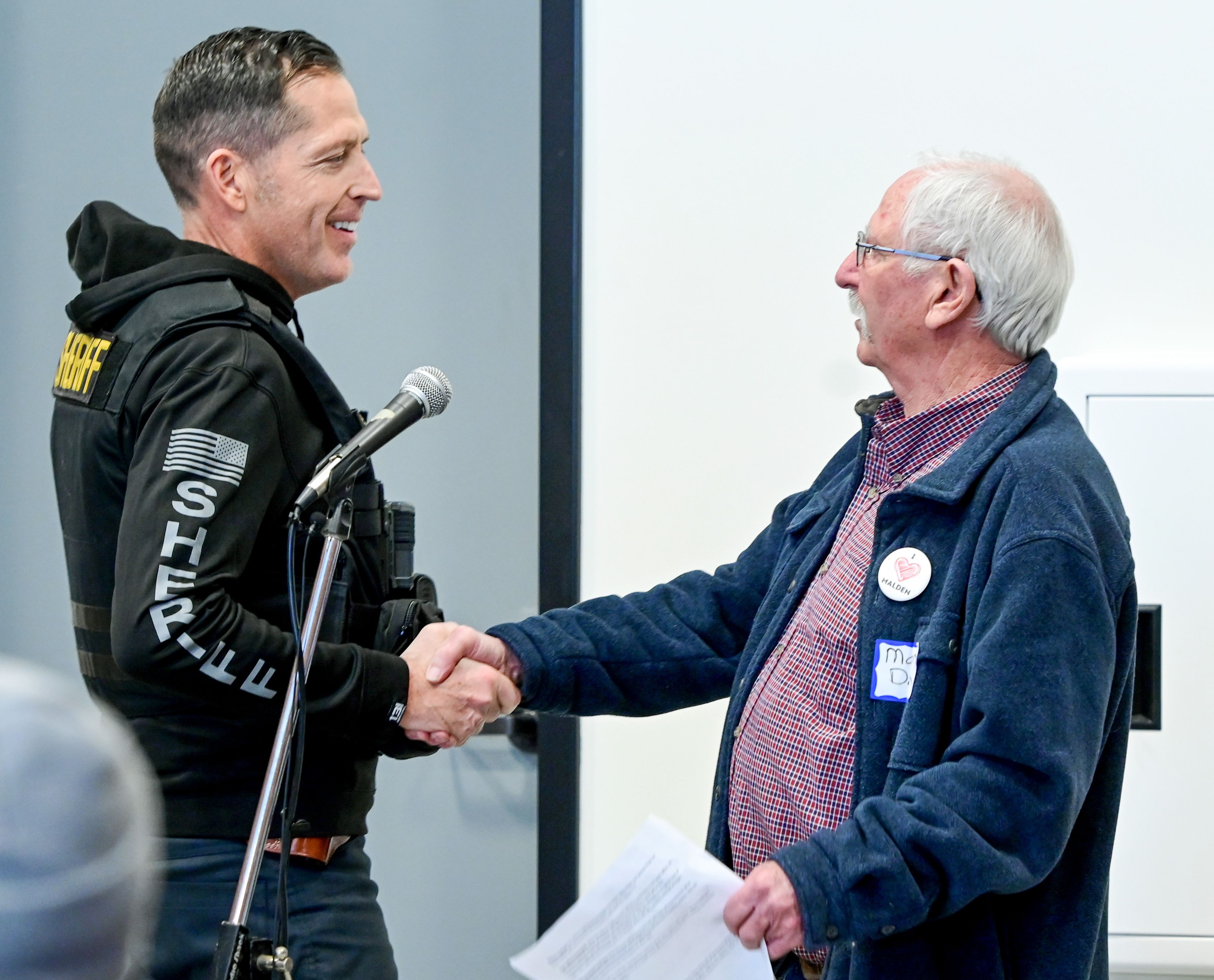 Whitman County Sheriff Brett Myers, left, shakes hands with Malden Mayor Dan Harwood at the town’s new facilities on Thursday.