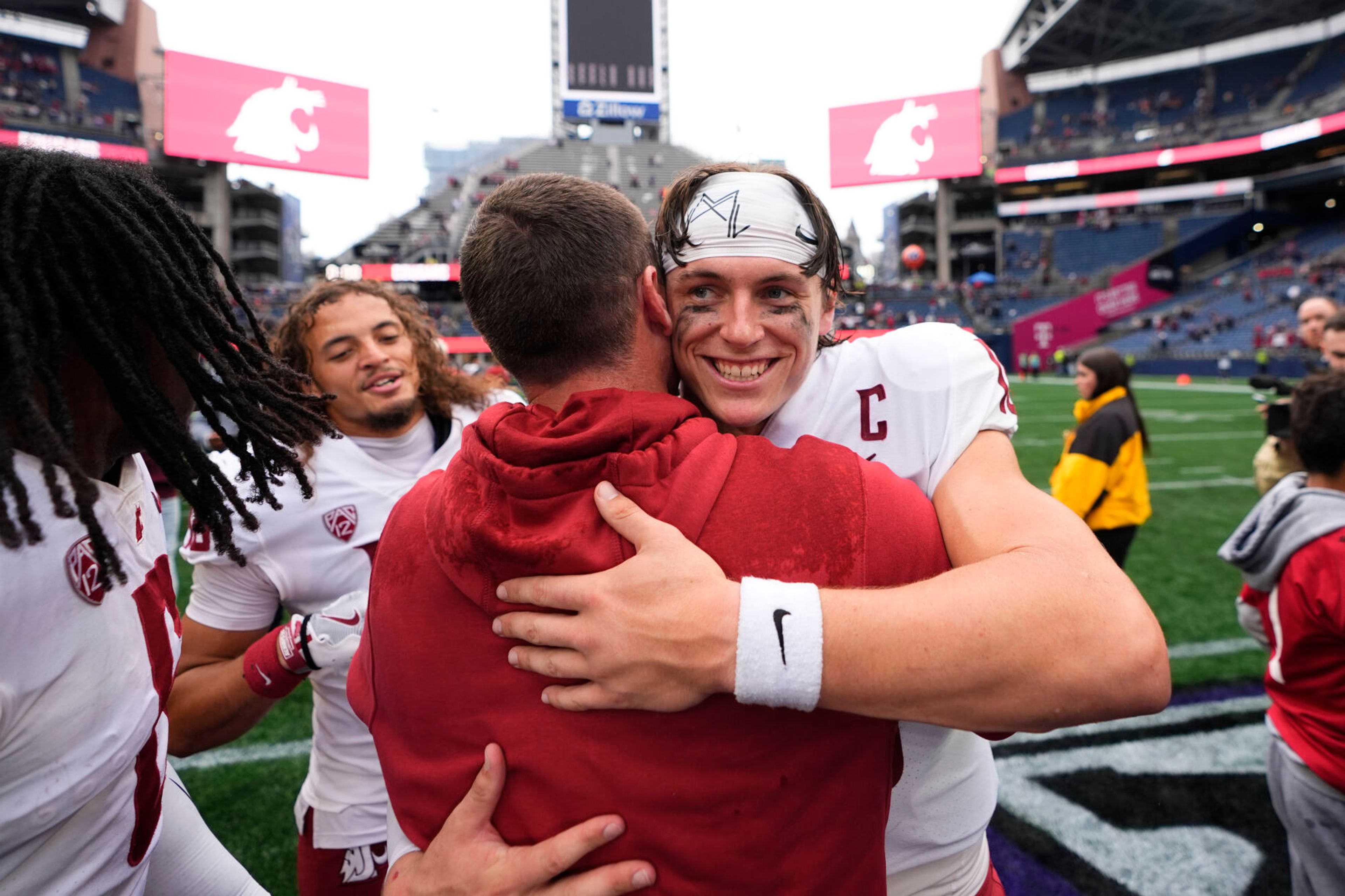 Washington State quarterback John Mateer, facing, hugs head coach Jake Dickert as they celebrate a 24-19 win over Washington in an NCAA college football game Saturday, Sept. 14, 2024, in Seattle. (AP Photo/Lindsey Wasson)