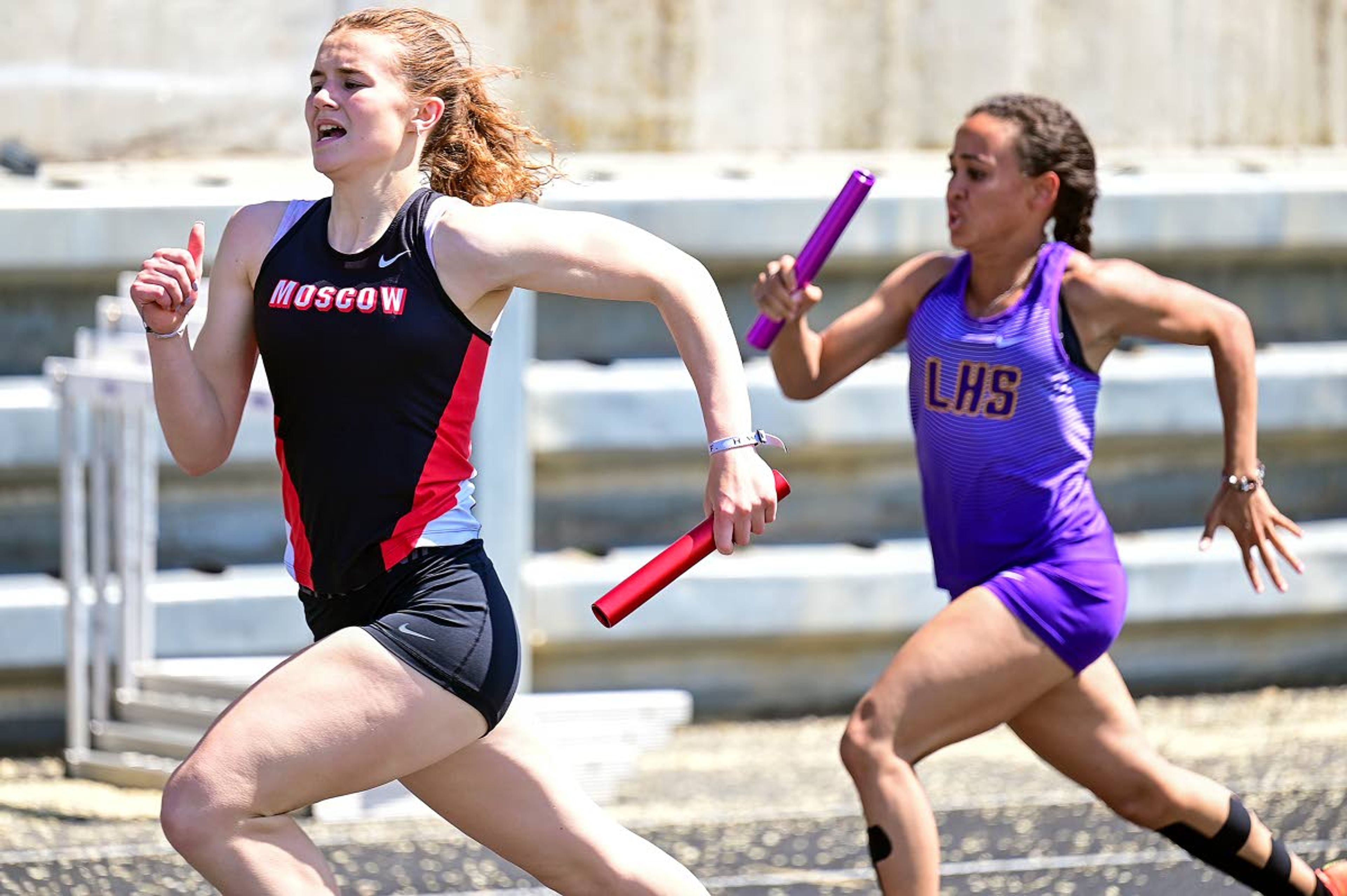 Moscow’s Angela Lassen edges Lewiston’s Trinity Trembley on their way to the finish line of the 800-meter relay on Thursday afternoon at the District II Meet of Champions at Vollmer Bowl in Lewiston.