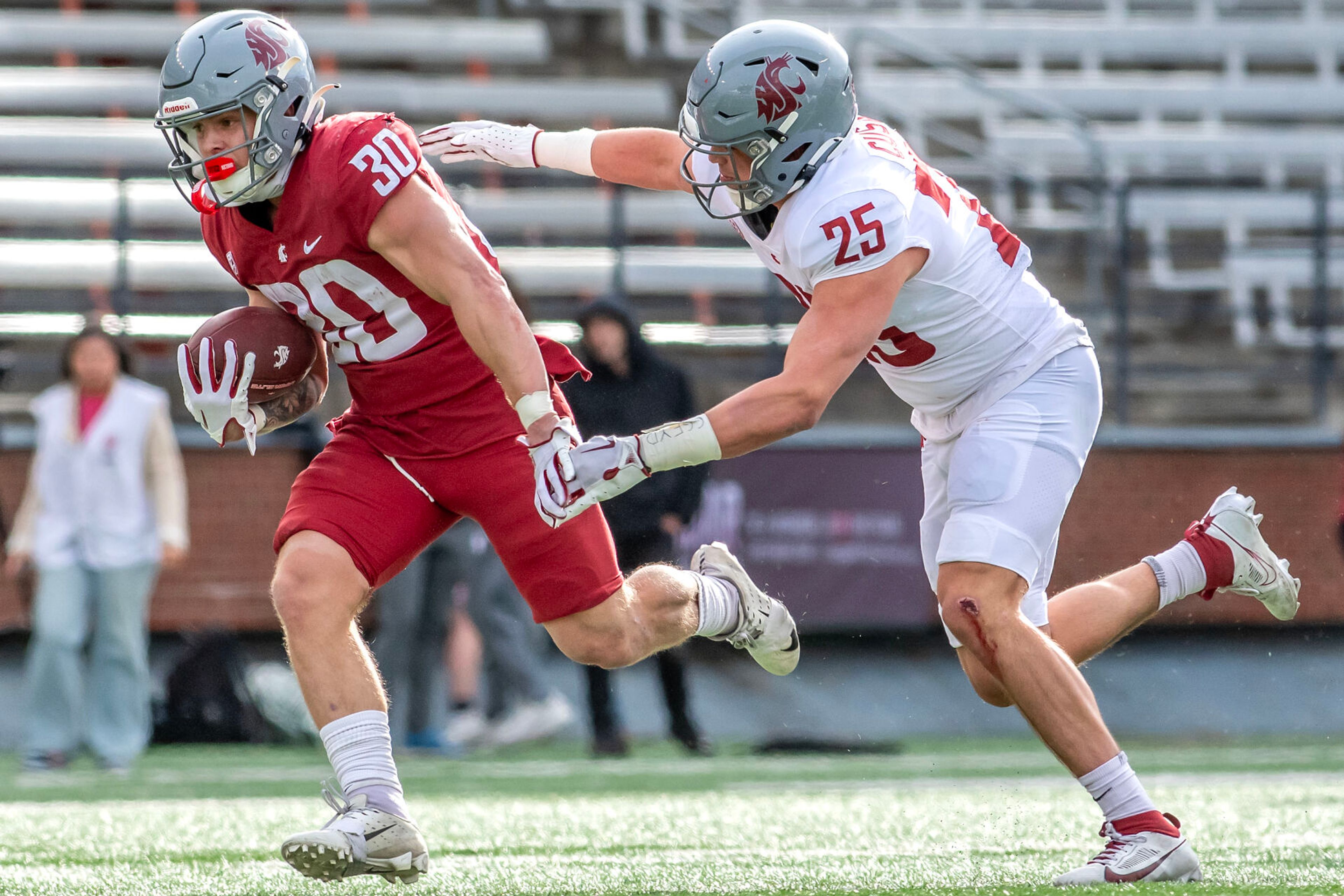 Crimson running back Dylan Paine runs the ball as Gray linebacker Frank Cusano looks to stop him in a quarter of the Crimson and Gray Game at Washington State University in Pullman.